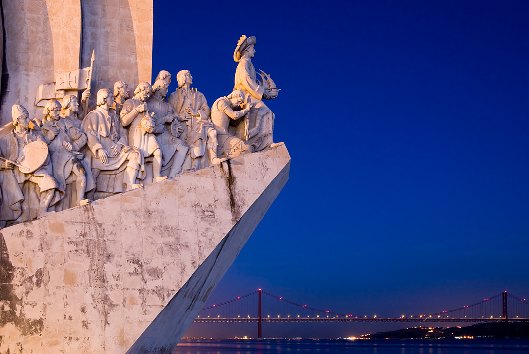 Pradao dos Descobrimentos. Monument of the Discoveries dedicated to Portuguese sea explorers and the 25 of April bridge at dusk. 