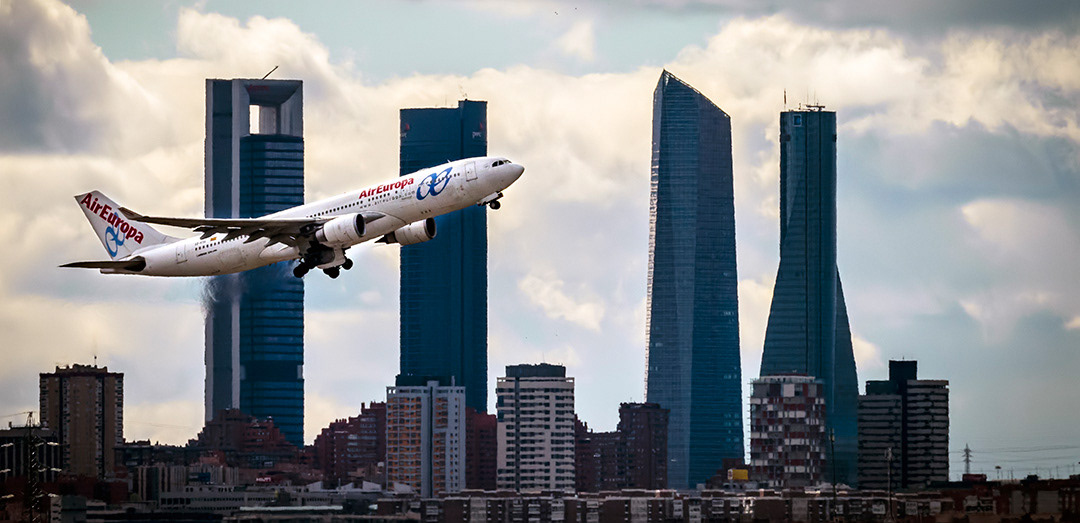 An Air Europa airplane takes off in front of the Cuatro Torres (Four Towers) business area (Madrid).