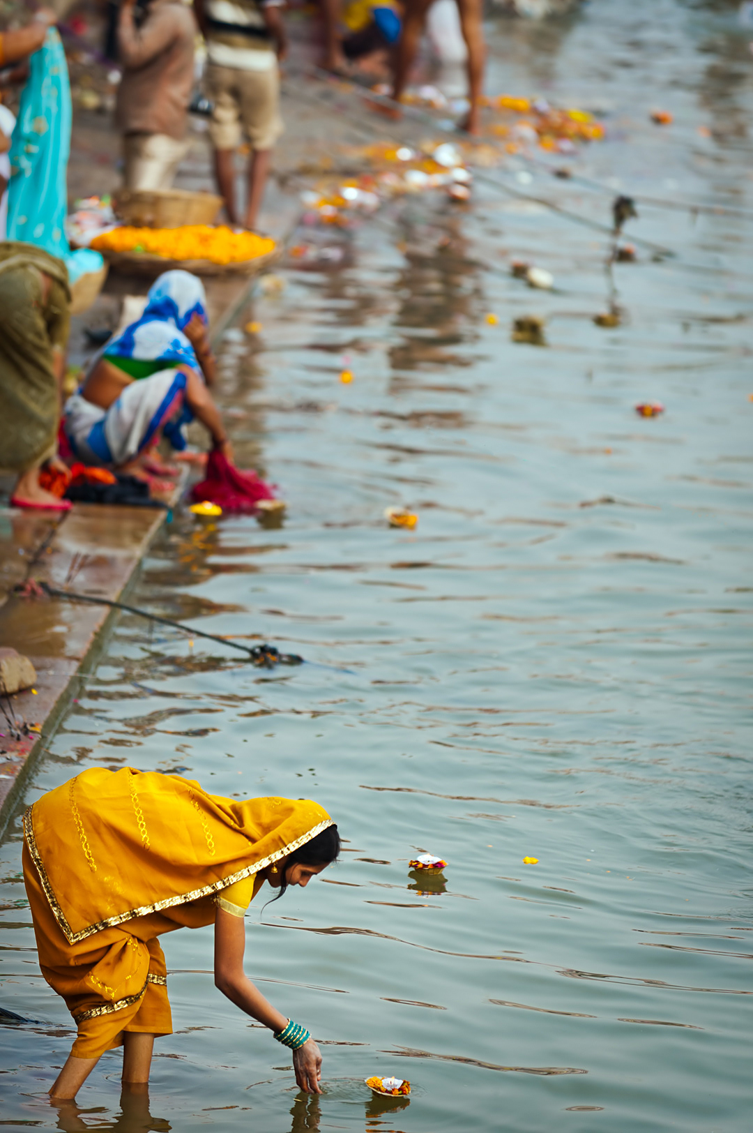 Woman making an offering in Ganges river, Varanasi. 