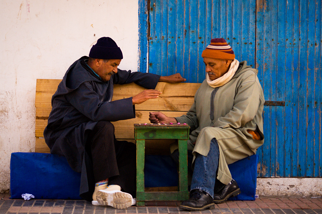 Two old men playing draughts in a Essaouira street.