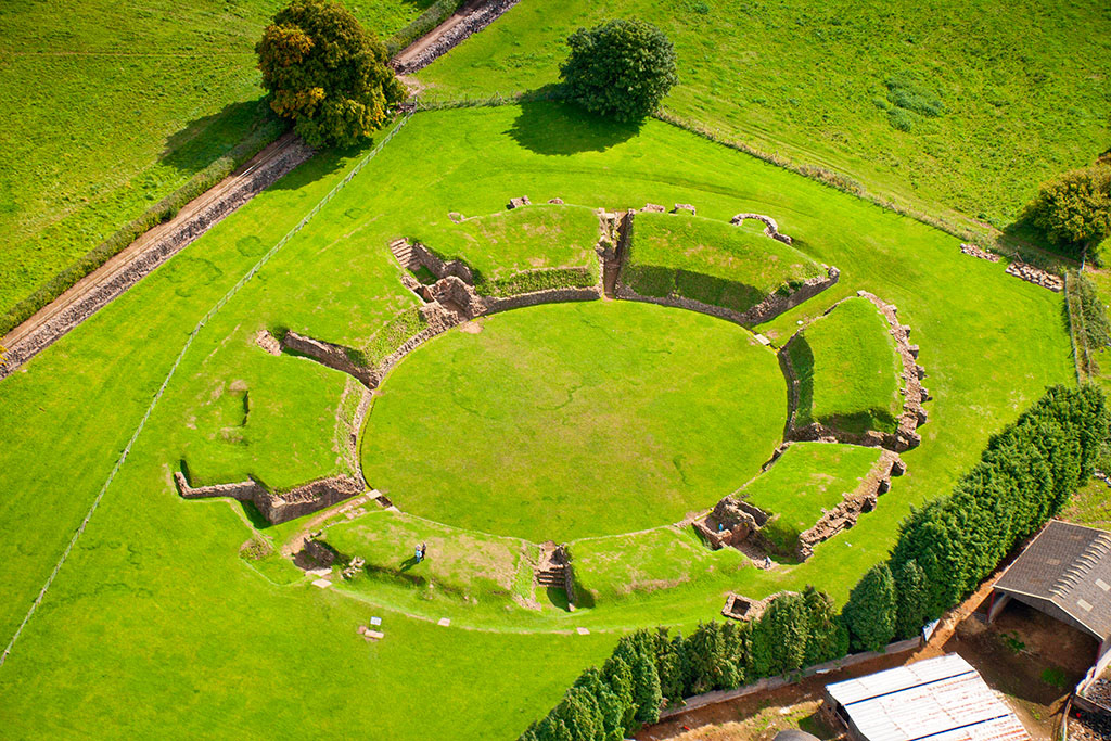 Ruins of a Roman amphitheatre in Caerleon, Wales, overgrown with grass