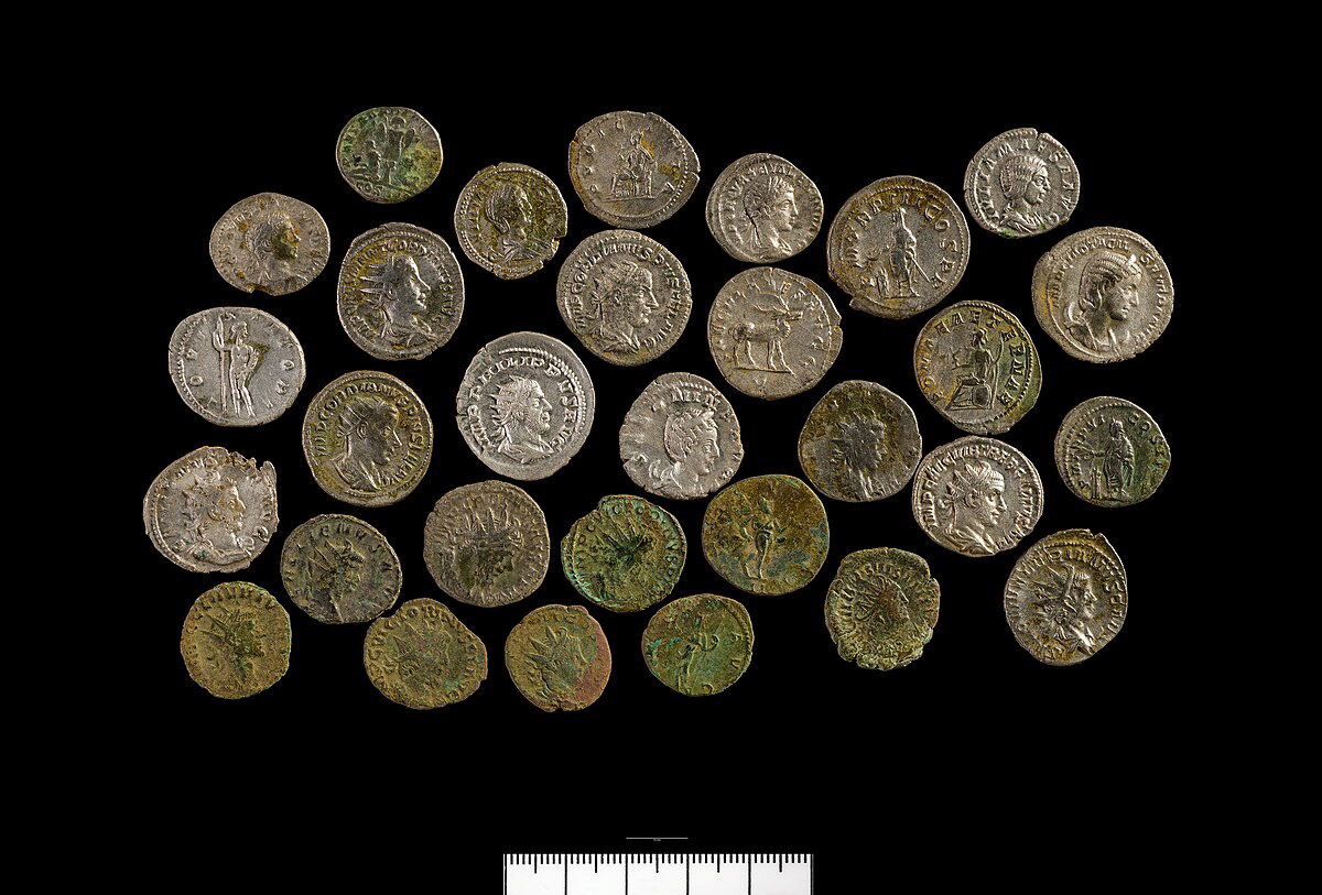 Thirty silver Roman coins on a black background