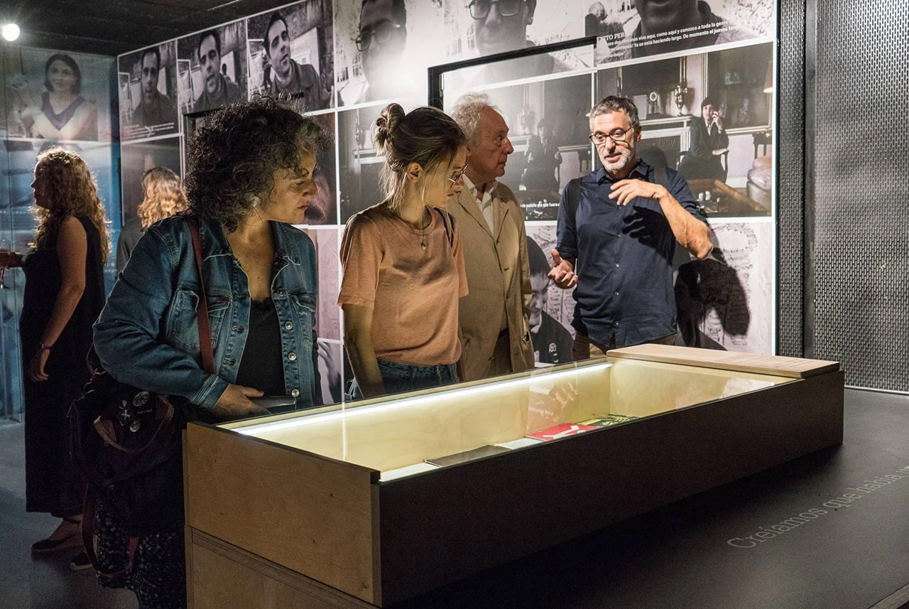 Visitors at the exhibition standing over a wooden box displaying some of the director's belongings.