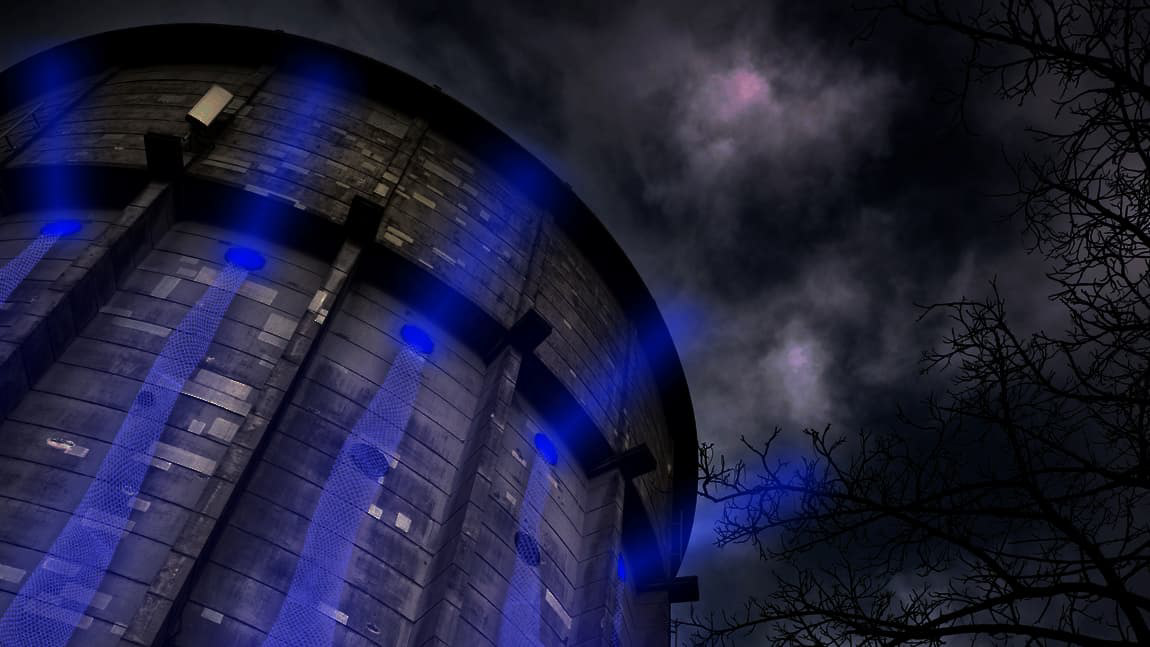 Perspective looking up at the blue light shining out of the tower, and mesh light running down the sides.