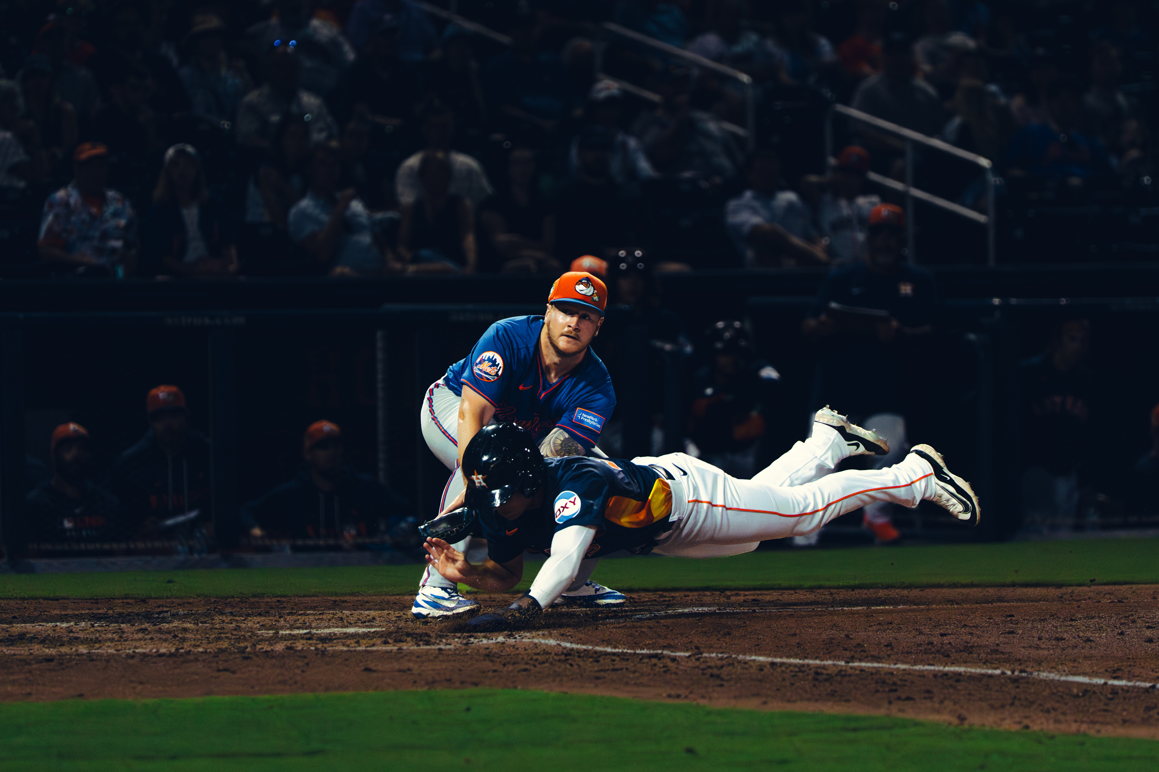 Houston Astros runner dives headfirst into home plate as the New York Mets catcher fields the throw during spring training at The Ballpark of the Palm Beaches, March 2026. Photo by Aday's Media Production