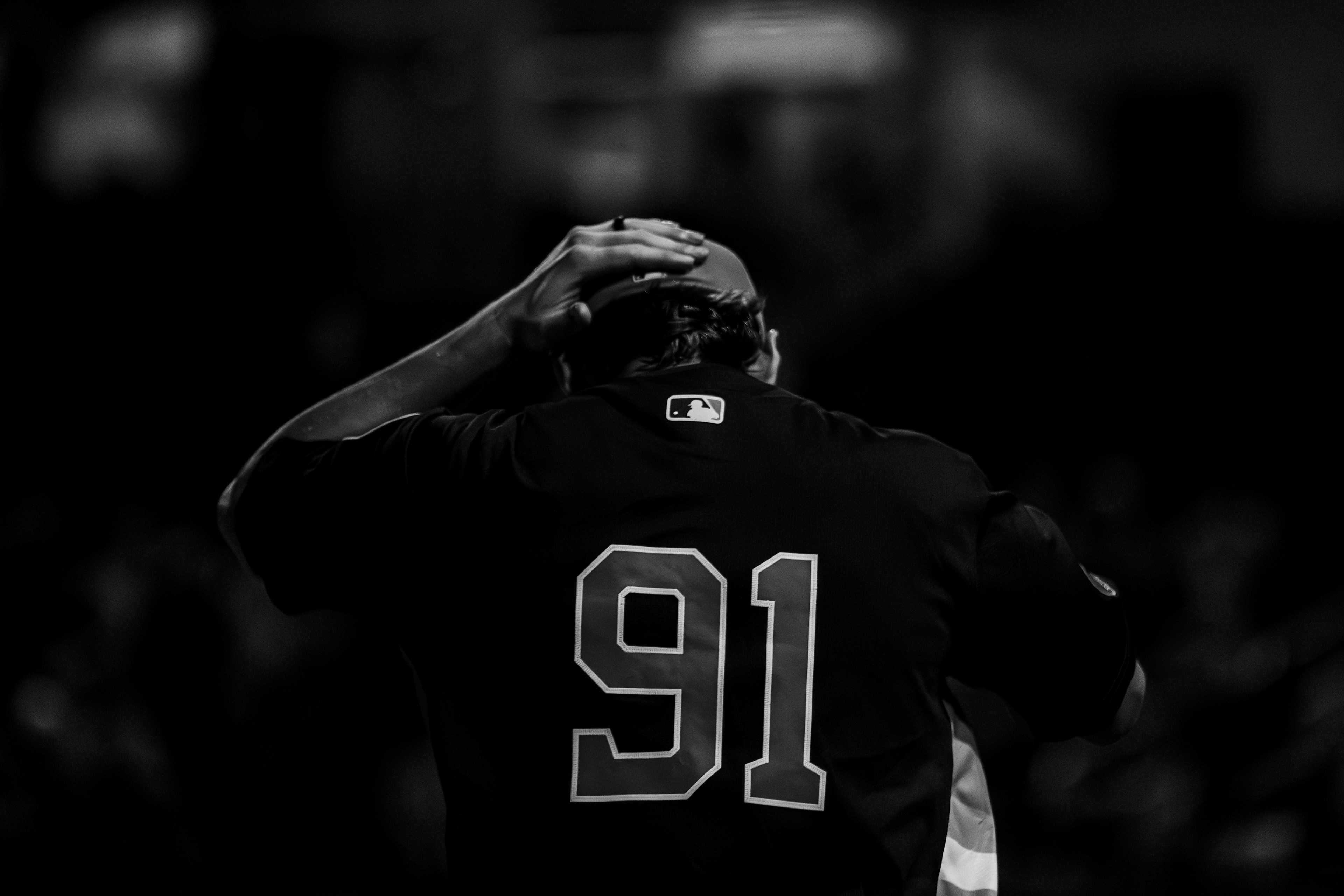 Close-up of Houston Astros number 91 from behind adjusting his cap showing the MLB logo on his jersey during spring training at The Ballpark of the Palm Beaches, March 2026. Black and white edit. Photo by Aday's Media Production
