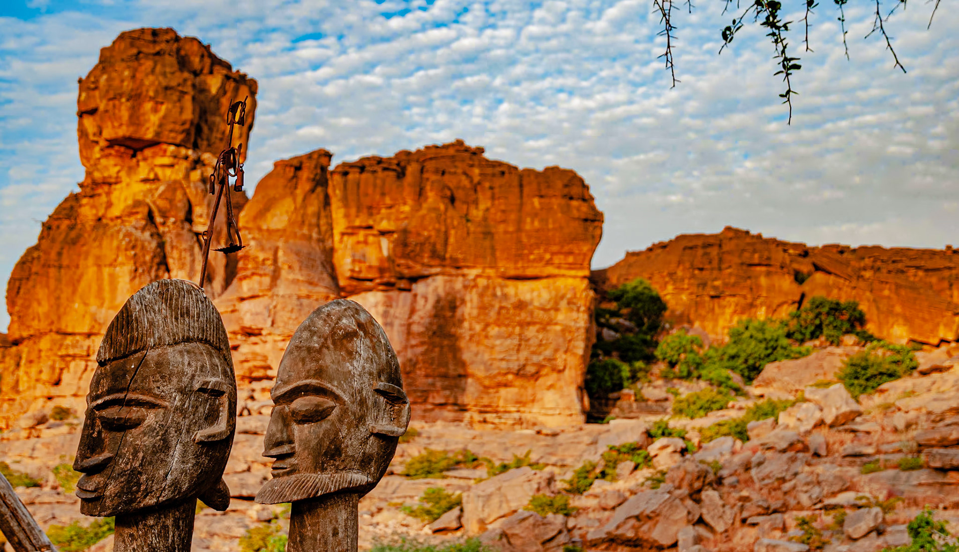 Two wooden carvings stand watch over the Bandiagara Escarpment, a 200 km jagged sandstone cliff lying near the Sahara’s southern limit. Mali's Dogon people do not have a written language; instead their carvings help tell their stories and preserve their oral history