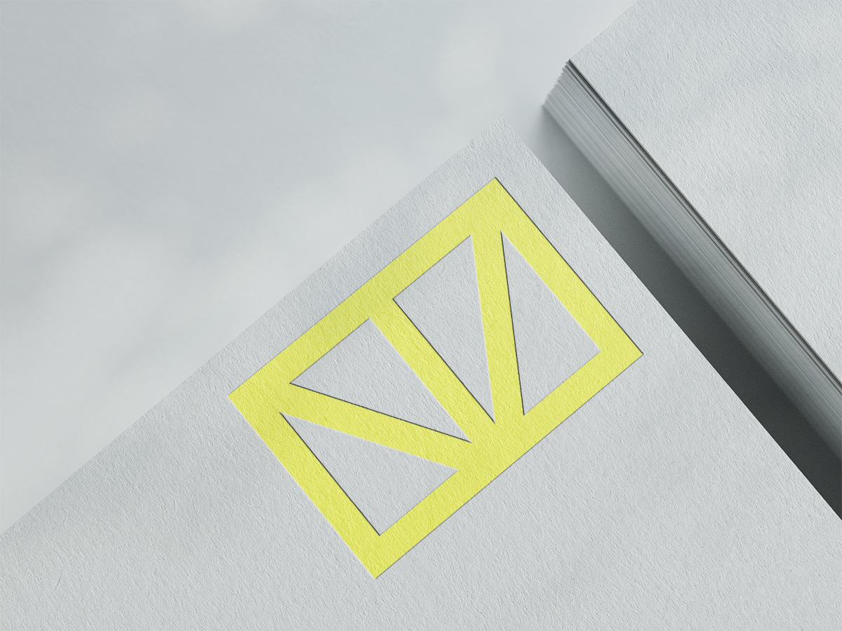Nahaufnahme eines Papierstapels worauf ein Rechteckig gerahmtes Lime Grünes Logo mit zwei diagonalen und einer vertikalen Linie im inneren zu sehen ist.