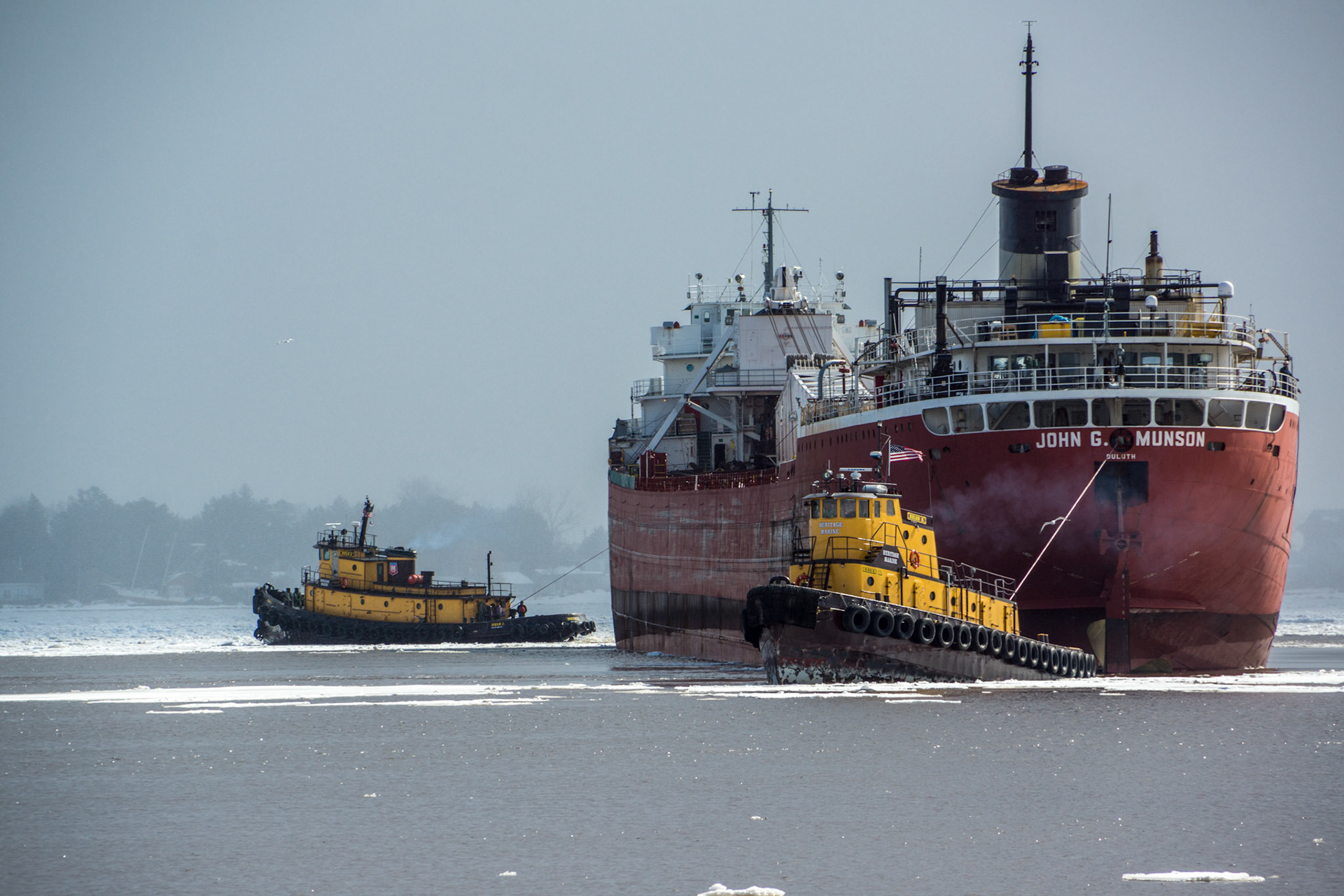 April 17 - Tugs at WorkTwo Heritage Marine tugs work away to pull the John G Munson out of an icy harbor.The powerful tugs made it easy to free Munson, who soon departed the harbor for another season of work."God is our refuge and strength, an ever-present help in trouble." - Psalm 46:1Sometimes, we need help from those around us, which is a humbling experience.