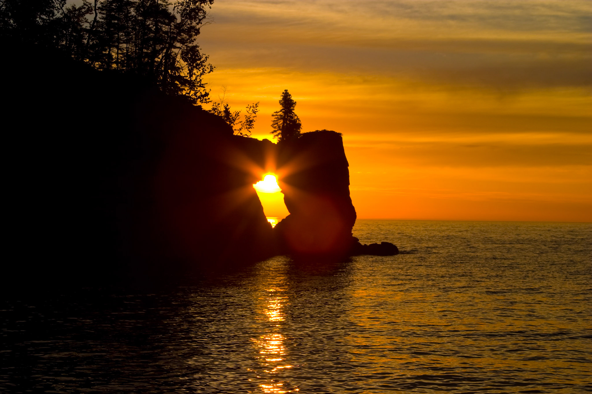 September 15 - Sunbeams through the Keyhole - Tettegouche is one of Minnesota's most beautiful state parks. It features a mile of Lake Superior coast, including the Baptism River mouth, cascades, and falls; four inland lakes; rugged semi-mountainous reliefs; and an undisturbed northern hardwood forest. While this structure has long since collapsed into the lake, its memory remains for many photographers.God's Glory"Have you commanded the morning since your days began and caused the dawn to know its place... Job 38:12