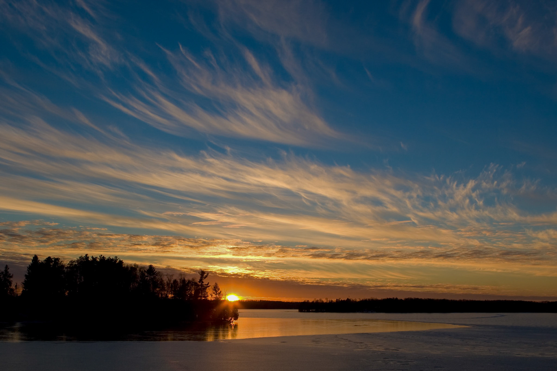The soft light of a cold November day fades into the distant horizon as winters ice, slowly grows acoss Caribou Lake.