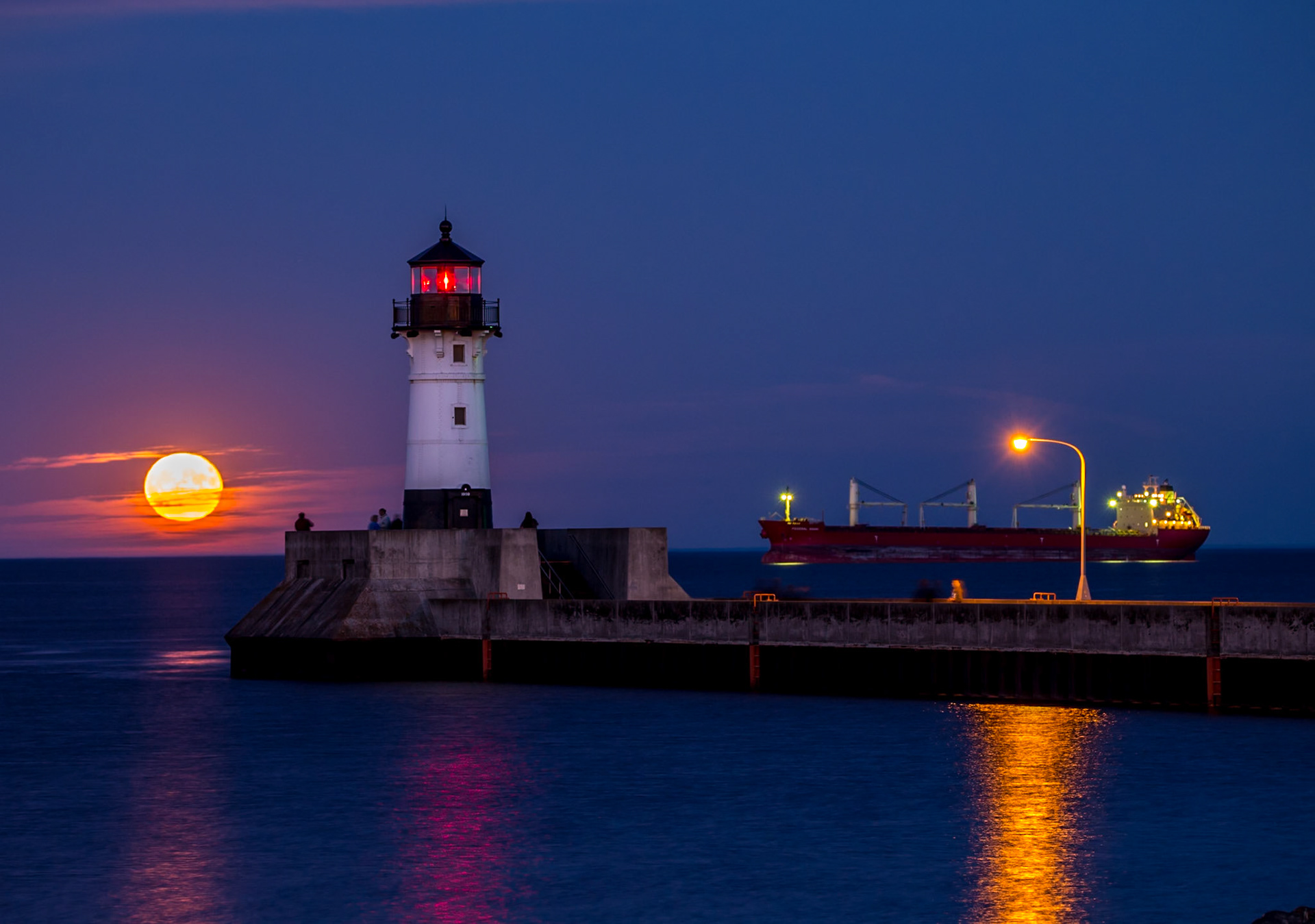 The federal Asahi waits at anchor off the Duluth Piers while the moon stids up through the horizon.