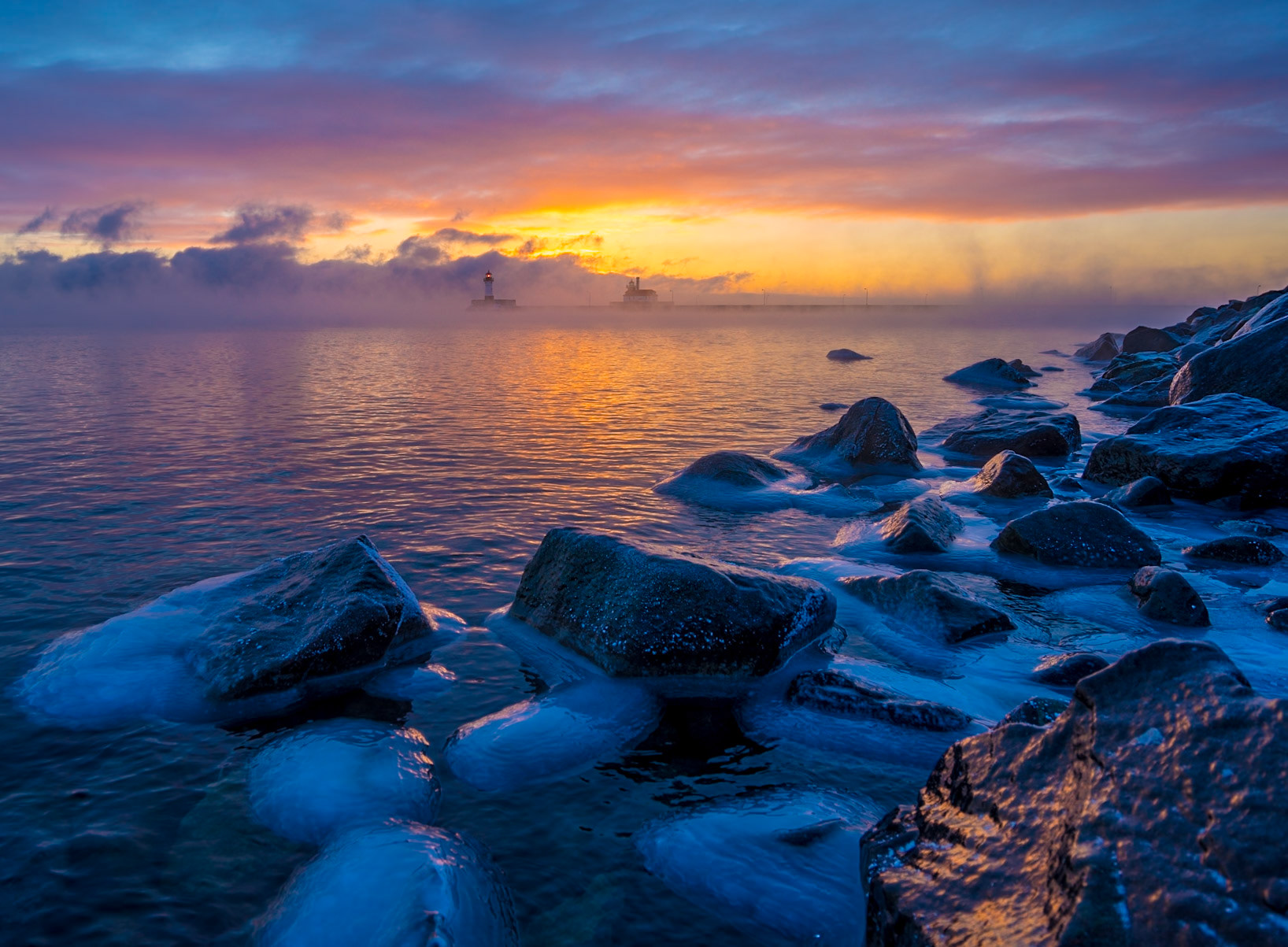 January 25 - Fire and IceWarm sunlight and ice-covered rocks blend, repeating a January scene across the Lake Superior shore.The winter season is filled with spectacular scenes, often never observed by anyone. Yet God creates them daily for His pleasure. Once in a while, we also get to enjoy them. So teach us to number our days so that we may present a heart of wisdom to You. Psalm 90:12Small changes in time go unnoticed in our busy lives, but time moves on by minute, days, months, and years, sometimes without notice. So, take a minute today to reflect on our blessings and thank God for each minute.