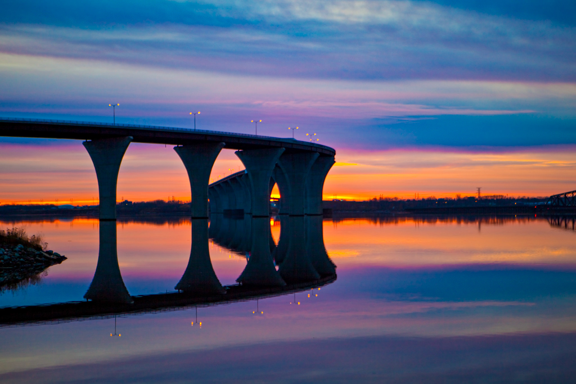 November 12 - Bong Bridge ReflectionThe Bong Bridge spans the St. Louis River between Duluth and Superior. November sunrises bring colorful reflections on the soon-to-be-frozen water.As in water, face reflects face, so the heart of man reflects the man. Proverbs 27:19