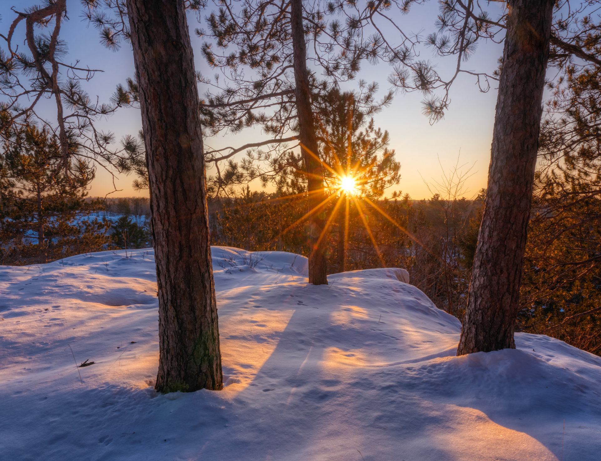 December 30th - Sunset Through the PinesThe winter sun slowly sets over the St. Louis River valley near Jay Cooke State Park.So that those who dwell at the ends of the earth are in awe at your signs. You make the going out of the morning and the evening to shout for joy. Psalm 65:8