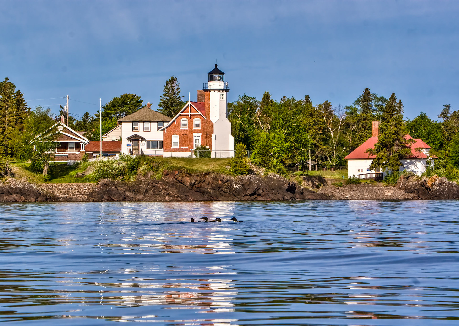 May 31st - The Eagle Harbor Lighthouse has stood watch over Lake Superior since 1850. Located at the northern tip of Michigan's Keweenaw Peninsula, Eagle Harbor Lighthouse is one of the most picturesque lights on the Lake. On this quiet May morning, the loons were playing in front of the light, while I floated in my kayak on the crystal clear waters of the mighty lake.