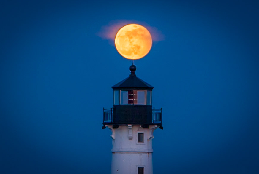 March 22 - Pointing to the MoonThe mid-March full moon drifted quietly into alignment with the Duluth North Pier Lighthouse. I nudged the tripod as the glowing disk appeared to touch the lightning rod—just for a breath—before rising into the night.March’s full moon occurs near the spring equinox, when the Moon’s path climbs at a shallower angle, lingering along the horizon a little longer. That gentle glide gives photographers a narrow window for precise alignments like this one.It’s easy to chase the perfect image. Yet moments like this remind us that creation unfolds with purpose, season by season.“He made the moon to mark the seasons;the sun knows its time for setting.” — Psalm 104:19The next time you see a full moon rise, pause and remember: its path was written long before we ever looked up.