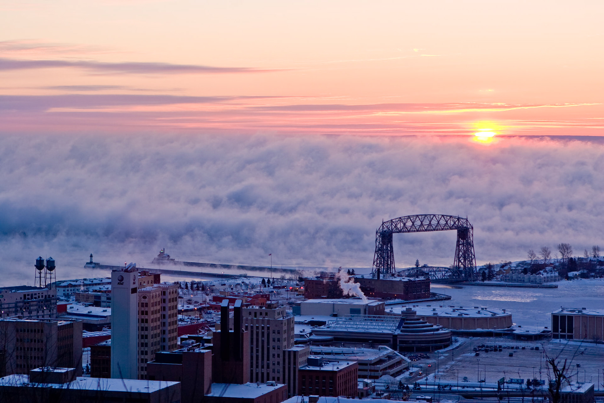 Warm colors a a winter sunrise casts a glow over steam clouds rising from Lake Superior on this -35 below zero morning.