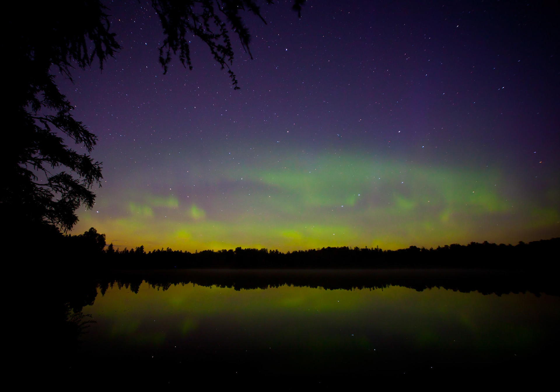 Stars shine through the Northern Lights on a calm October night.