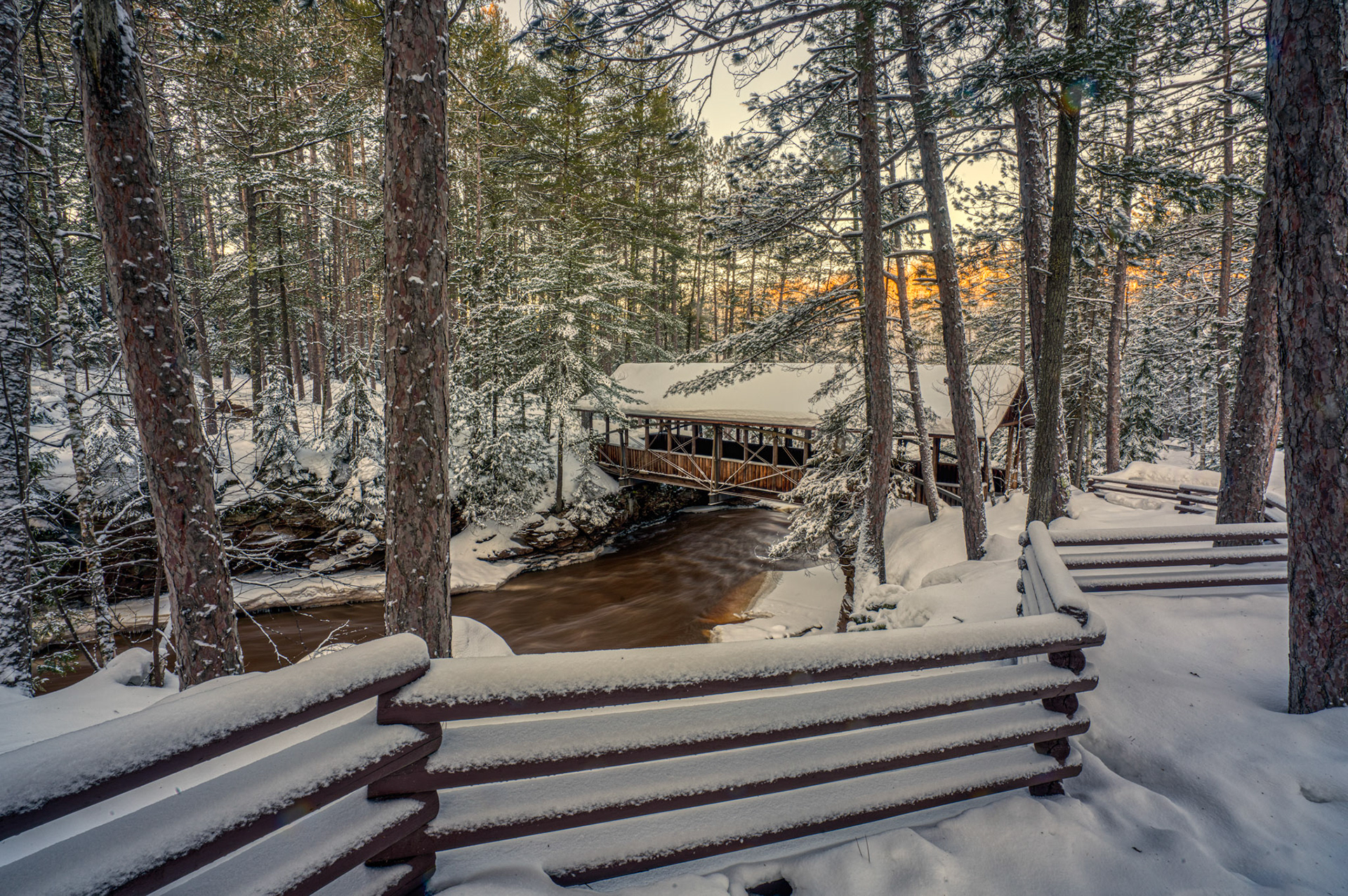 December 21 - Winter SolsticeThe Covered Bridge at Amnicon State Park in Wisconsin sits in a quiet, snow-covered valley, waiting until spring. With -20F temperatures, the bubbling rivers seem ready to be encased in ice for a few months' rest.As the winter solstice approaches, the days shrink while the nights stretch. Yet, amidst the darkness and cold, a sense of peace and stillness emerges. The quiet beauty of the snow-covered landscape calms and invigorates our spirits. This season may remind us to slow down and appreciate the simple joys of life, like warming ourselves with a cozy fire or losing ourselves in a good book. As we prepare to welcome the longest night of the year, let us embrace the beauty of this season and the chances it provides for rest and reflection.  In peace, I will both lie down and sleep; for you alone, O Lord, make me dwell in safety. Psalm 4:8