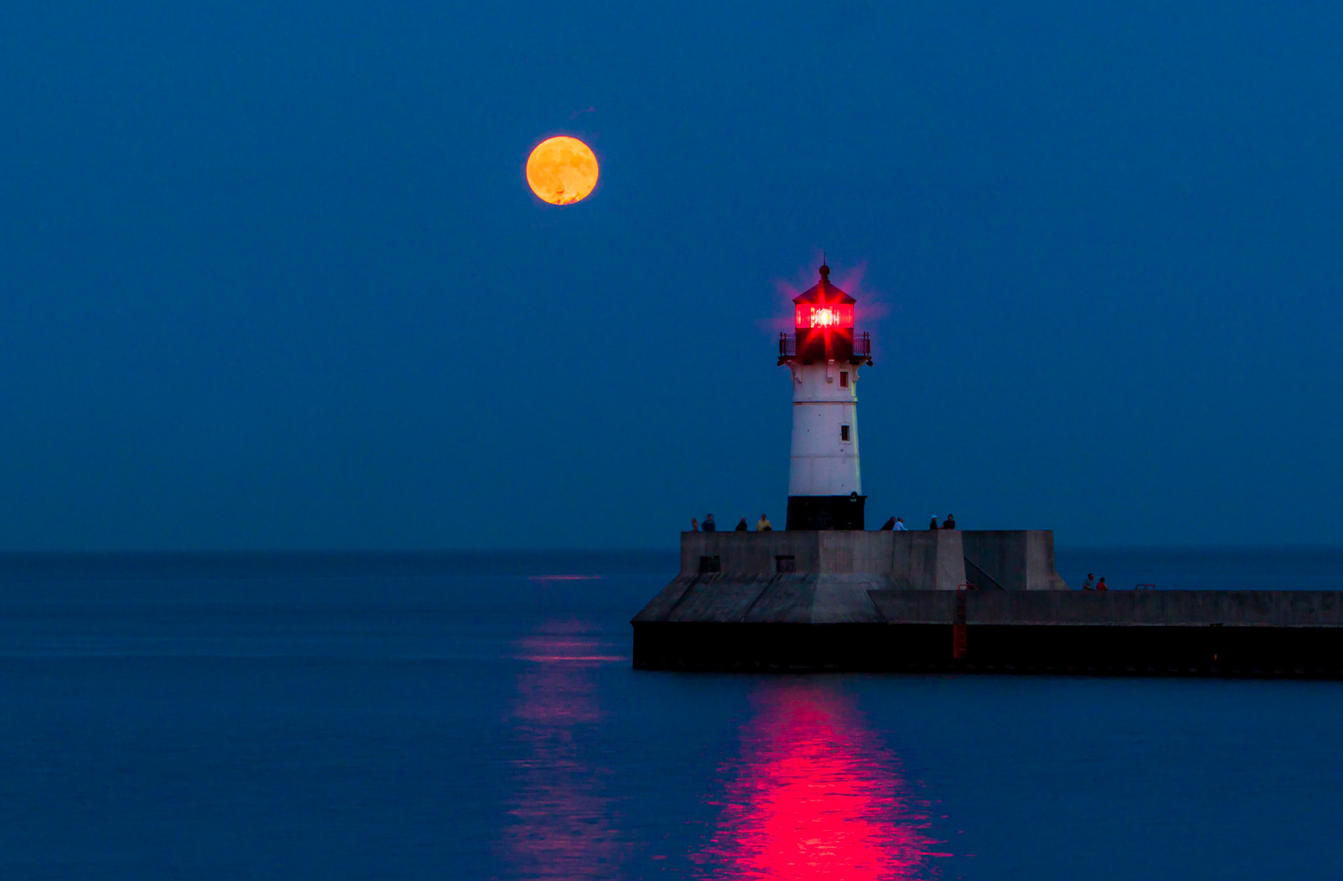 September 6 - Moonrise watchers - As twilight settles over Duluth, the North Pier Lighthouse stands like a solitary sentinel at the edge of Lake Superior. The sky, a twilight tapestry of dusky blues and purples, is a dramatic backdrop for the rising moon. As it ascends higher into the night sky, its beams highlight the architectural details of the historic lighthouse. .Praise him, sun and moon, praise him, all you shining stars! Psalm 148:3
