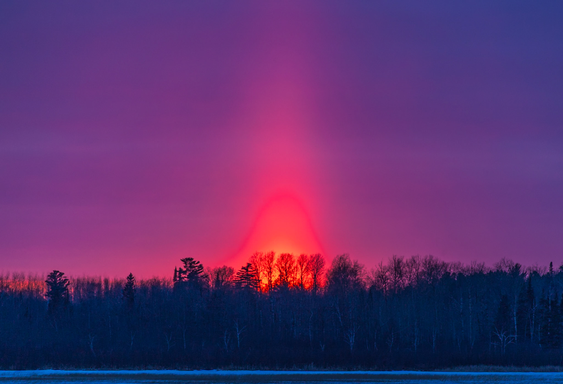 March 28 — March Sun PillarThe sun pillar that formed over Caribou Lake in this image is one of those quiet atmospheric moments that feels almost supernatural the first time you witness it.A sun pillar forms when flat, plate-shaped ice crystals drift through very cold, calm air. As the sun sinks low on the horizon, its light reflects off these suspended crystals, creating a vertical column that seems to rise straight into the sky. Late March in northern Minnesota is prime time for this phenomenon. Winter may be loosening its grip at ground level, but high above, the cold still lingers — just enough to catch the light.The pillar lasted only a few minutes before fading into twilight. Brilliant. Vertical. Gone.There is something powerful about light reaching upward in the darkness. Creation does not speak randomly; it consistently reflects its Maker.“For with You is the fountain of life; in Your light we see light.” — Psalm 36:9Like the sun pillar, our time is brief. Shine while you can. Let your life reflect the Light that never fades.