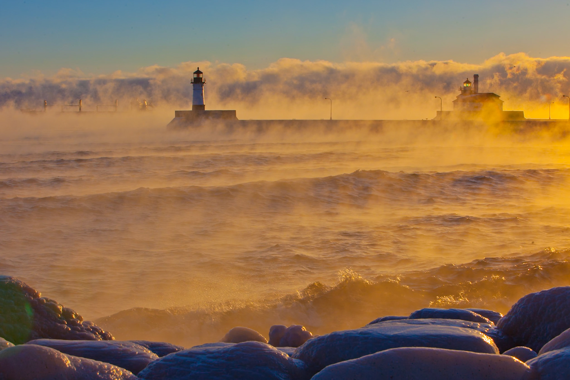 Steam fog coming off the surface of Lake Superior rises in stark contrast to the warm morning lignt.