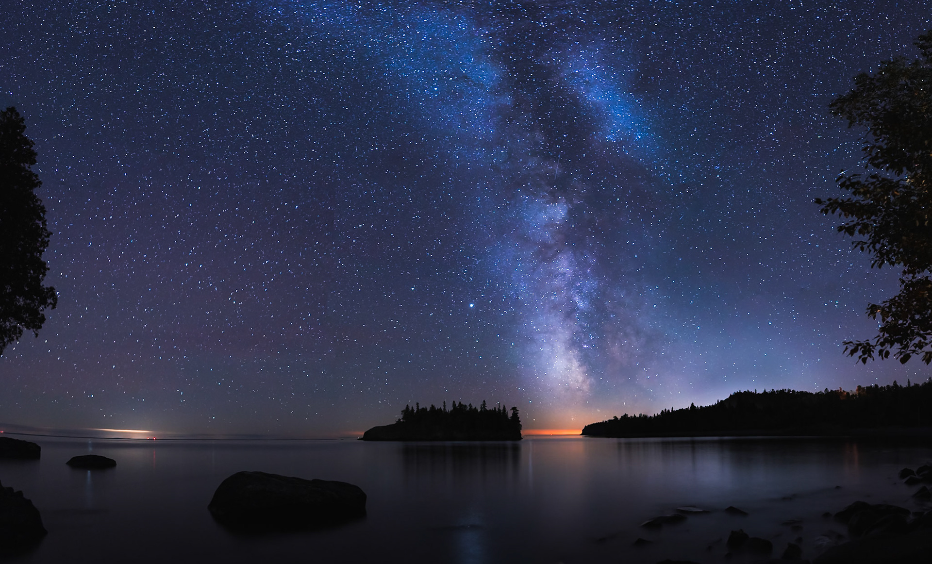 September 17 - September Skies - The Milky Way shines over the North Shore of Lake Superior with the lights of Two Harbors in the background.The Milky Way Galaxy is an incredible work of creation and is home to our earth. The galaxy is 150,000 light-years in diameter. Our Solar System resides roughly 27,000 light-years away from the Galactic Center, on the inner edge of one of the spiral-shaped concentrations of gas and dust particles called the Orion Arm.When I look up into the nighttime September skies, the work of God's creation is apparent and humbling. God's Glory: The heavens declare the glory of God; the skies proclaim the work of his hands. Day after day, they pour forth speech; night after night, they reveal knowledge. They have no speech; they use no words; no sound is heard from them. Yet their voice goes out into all the earth, their words to the ends of the world. (Ps. 19:1-4)