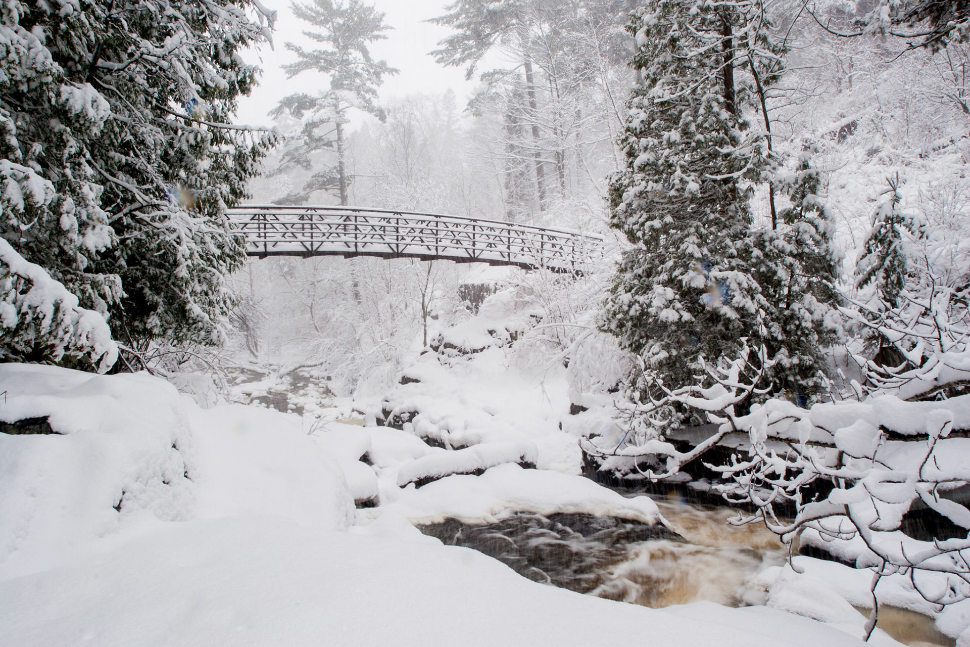 March 31 – Springtime Snow!March is a season of transition in the Northland, often bringing winter scenes that remind you not to plant your garden just yet. Heavy snow blankets Chester Creek in Duluth here, even as spring runoff rushes beneath it.Late March snowstorms occur because winter still lingers in the atmosphere, even after spring officially begins. Cold Arctic air can collide with warmer, moisture-rich air moving north, strengthening storm systems and producing heavy, wet snow. Lake Superior, near its coldest point of the year, helps keep shoreline temperatures low and can enhance snowfall. March truly becomes a battleground month when winter and spring clash — and powerful storms often result.Though the snow may be short-lived, its life-giving water is a welcome provision for the coming seasons."For as the rain and the snow come down from heaven and do not return there but water the earth, making it bring forth and sprout, giving seed to the sower and bread to the eater..." — Isaiah 55:10Sometimes the temporary difficulties of life become unexpected blessings. With a shovel in hand, give thanks for another beautiful day to be alive.