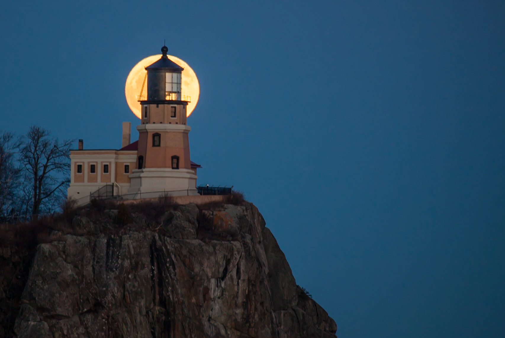 January 31 - Moon LightThe solar system's rotation, a testament to divine order, continues its perfect timing year after year, month after month. And so, photographers flock to Split Rock Lighthouse on the one night a year when the moon rises behind the lighthouse.Although the one night changes with the calendar date, the full moon is sure to rise behind the lighthouse on the night of the full moon.The anticipation of seeing the moon crest the cliff as it slides out from behind the lighthouse is always an enjoyable observation for any photographer. "He stretches out the north over the void and hangs the earth on nothing." Job 26:7. What a wondrous act of creation, a reminder of the divine's unfathomable power and wisdom. Thank you, Lord, for your creation that points to You, and for the exquisite beauty of winter that we are privileged to enjoy and live in.