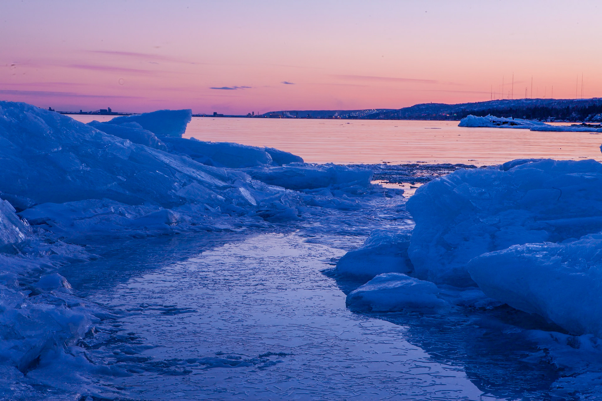 March 14 – Magenta IceDeep colors from a saturated sky reflect across cold waters, warming Lake Superior as another March day comes to a close in the Northland.The ice formations retreat into the lake, as if surrendering to the inevitable rise of mid-March temperatures.There is something profoundly calming about standing still and taking in a scene like this. It marks the end of one season and the beginning of another, as we March in step with the passing of time.“He made the storm be still, and the waves of the sea were hushed.” — Psalm 107:29Gratitude for fresh air and calm waters brings peace to the soul. Another day drifts into the past, and the hope of tomorrow gently accents a moment we will never have again.