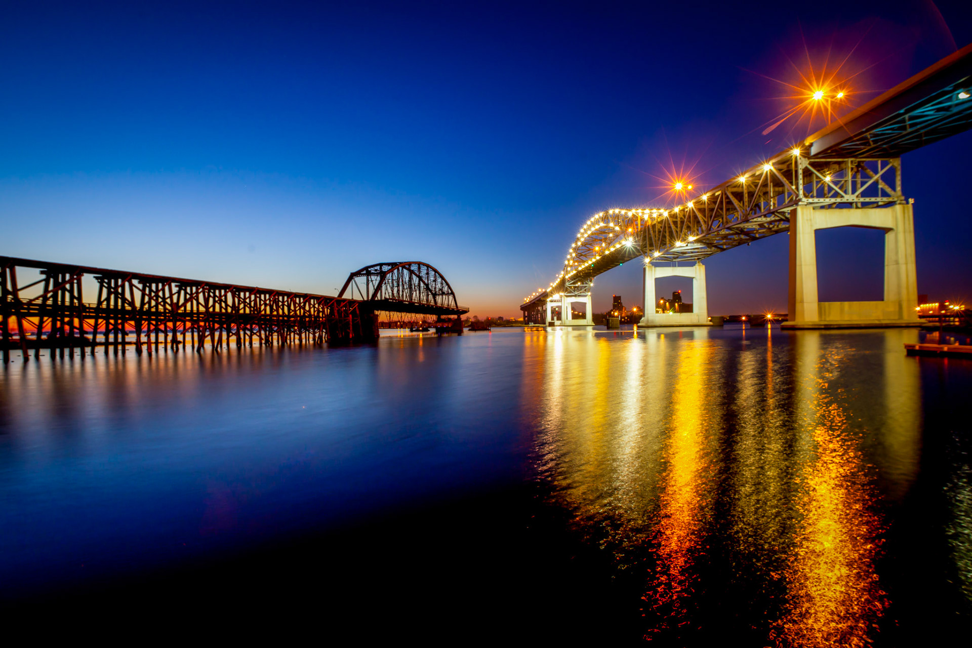 November 15 - ConvergenceIn contrast, the old Interstate Bridge stands to the Blatnik Bridge in the twilight of a November evening.As I stood there on the fishing dock, viewing the two bridges, I couldn't help but feel a sense of awe. The Blatnik Bridge, with its sleek design, represents today. On the other hand, the old Interstate Bridge, with its rusted metal and rotting wood, represents the past. It reminded us of the struggles and challenges that led us to where we are today. Yet, as I gazed at both bridges, I realized they were part of the same story - the story of our harbor and the people living here.I remember the days of old; I meditate on all you have done; I ponder the work of your hands. Psalm 143:5