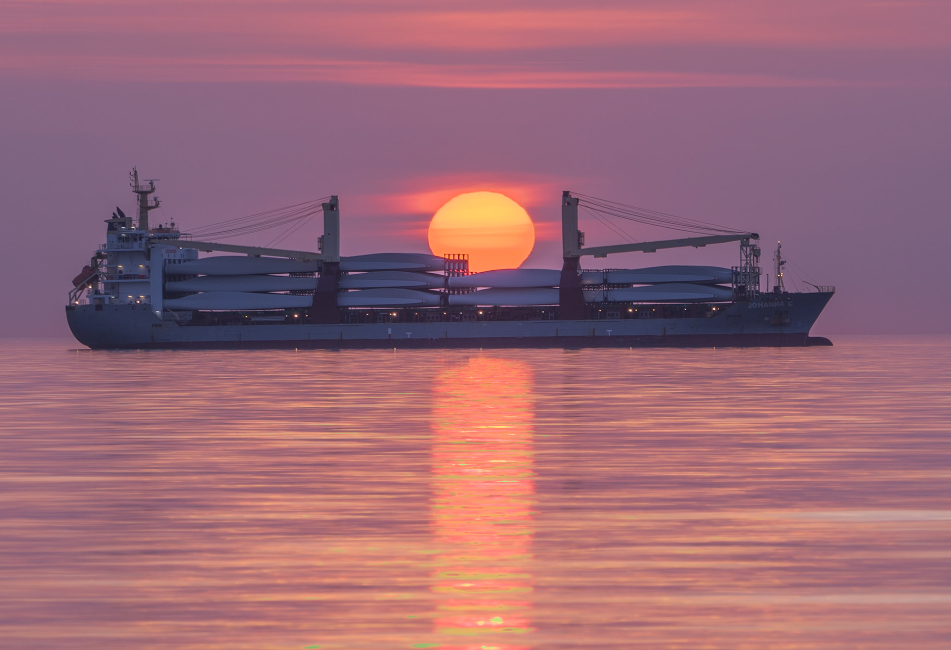 April 28 - Sunrise ShippingThe Johanna C waits at anchor with a load of wind turbine blades ready for delivery. Sunrise is a fabulous time to watch and reflect on yesterday and set your sails for the day ahead."Teach us to number our days, that we may gain a heart of wisdom." - Psalm 90:12If we can learn to take things a day at a time, we can relax, knowing that most things are out of our control.