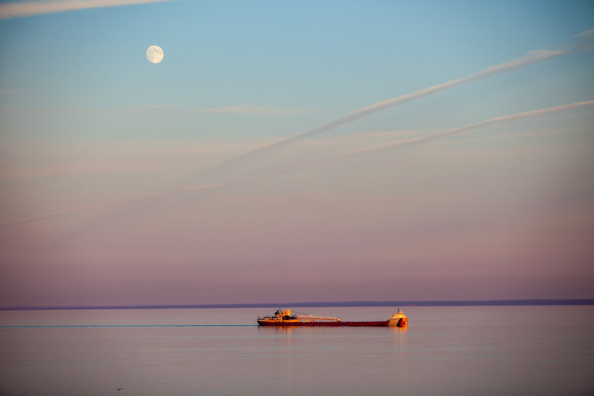 September 11 - VastnessThis photo captures an awe-inspiring view of Lake Superior, with its vast expanse of sparkling magenta-tinted waters stretching as far as the eye can see. In the distance, the laker, Arthur M. Anderson, can be seen moving slowly on the waves, a mere speck in the lake's vastness. Above all, the moon hangs suspended in the sky, adding an ethereal glow to the mesmerizing scene. It's a breathtaking sight that speaks to creation's immense power and beauty, leaving the viewer feeling humbled and inspired.Every day presents views like this around the big lake; remember to take the time to stop and appreciate the blessing of today.For by him, all things were created, in heaven and on earth, visible and invisible, whether thrones or dominions or rulers or authorities—all things were created through him and for him. Colossians 1:16