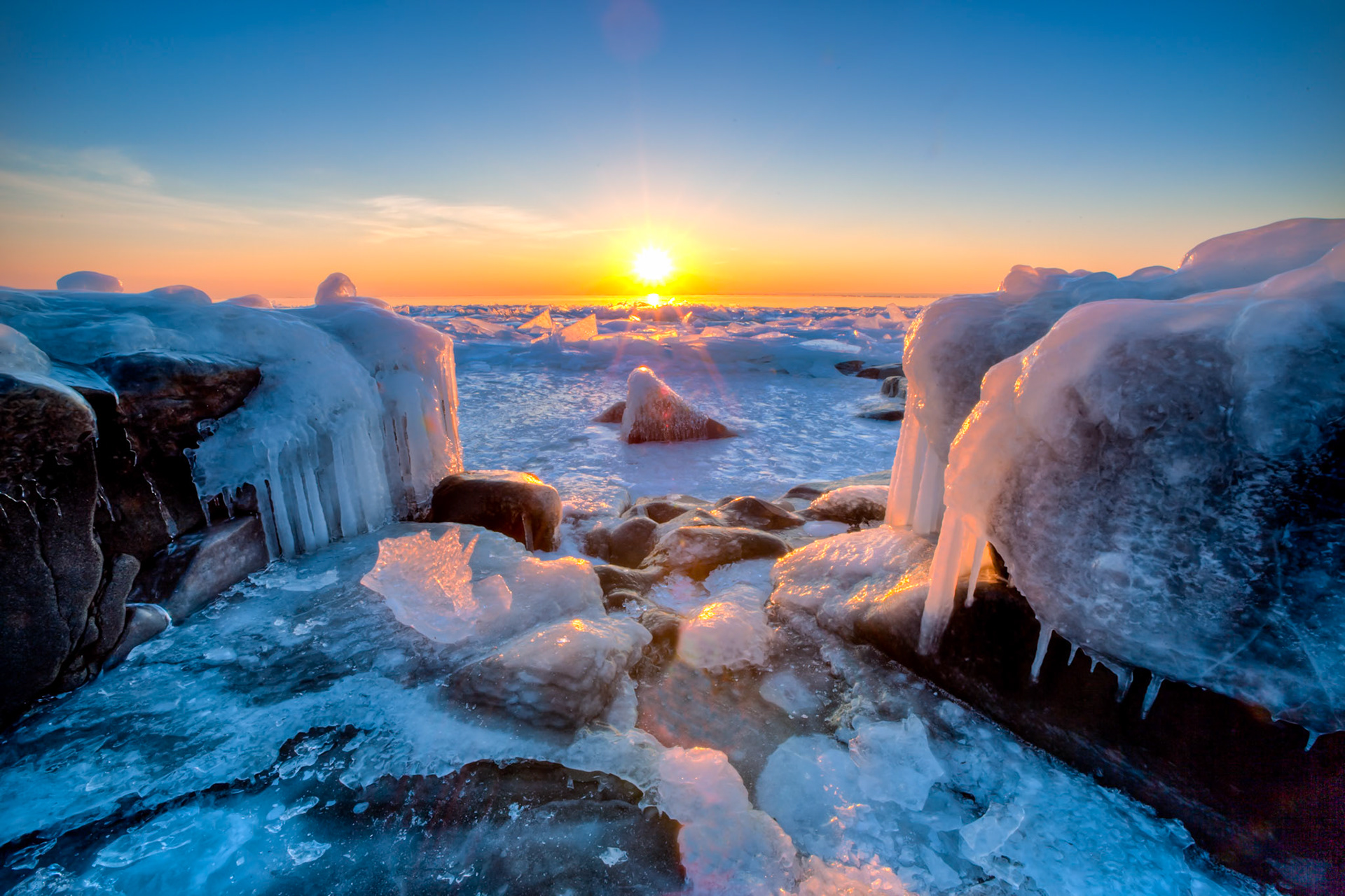February 5 — Superior WinterThe ice field stretches about half a mile into Lake Superior, creating a stunning natural gallery that plays with light throughout the day. The ice operates like thousands of tiny prisms, reflecting and refracting sunlight.As the sun shines through clear and semi-clear ice, the unique crystal structures and trapped air bubbles bend the light in various ways, creating ever-changing patterns of color and brightness, making the scene truly mesmerizing.As with most things in photography, it all comes down to light. Here, the northern landscapes of February are painted with an icy brush, guided by a master’s touch.“The people who walked in darkness have seen a great light;those who dwelt in a land of deep darkness, on them has light shined.” — Isaiah 9:2With more than two months of winter behind us, only a few short weeks remain to enjoy this season. Spring is approaching, and time continues its steady flow.