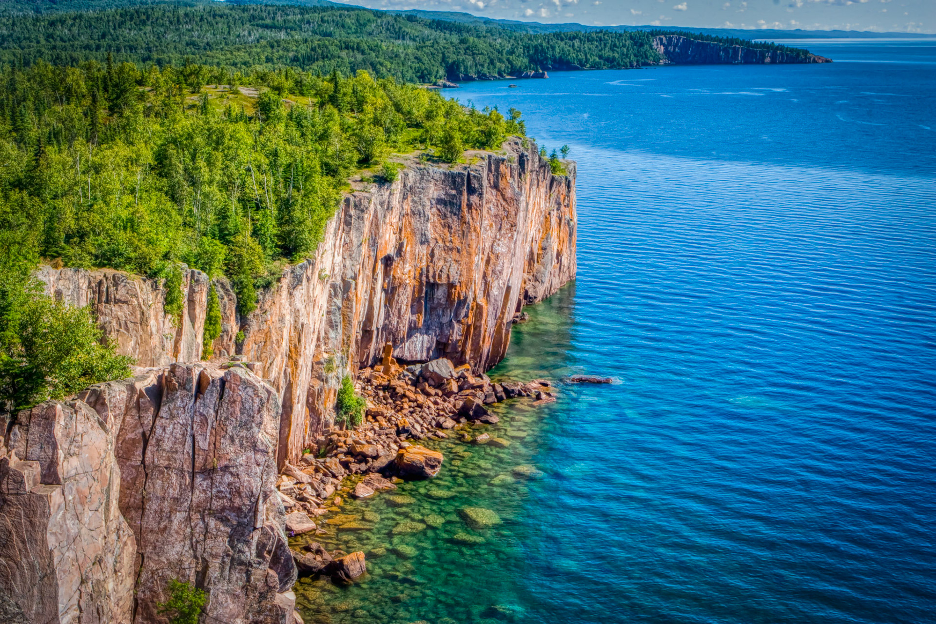 July 29 - Summer Splendor - Palisade Head near Silver Bay, MN, on the North Shore of Lake Superior, is a hidden gem for photographing the shoreline of the big lake.The lichen-covered sheer cliffs drop 300 feet into the crystal-clear water. As you gaze into the distance, you can spot the adventurous Shovel Point at Tettegouche State Park, a thrilling spot that draws rock climbers from far and wide.The LORD is my rock, my fortress, and my deliverer; my God is my rock, in whom I take refuge, my shield and the horn of my salvation, my stronghold. Psalm 18:2