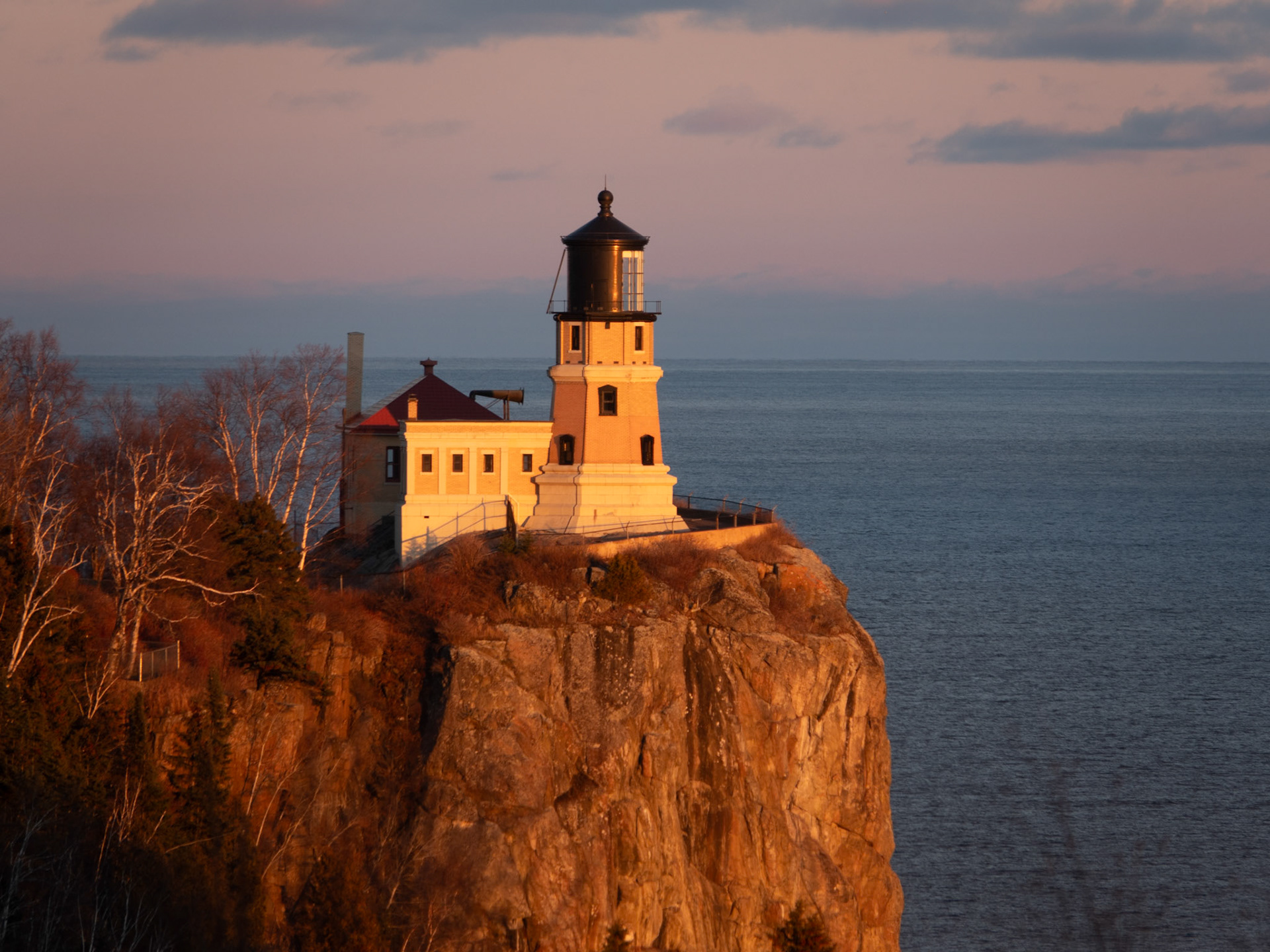 November 25 -Split Rock - the Superior SentinelSplit Rock Lighthouse stands sentinel over Lake Superior on a cold November day, bathed in the warm light of a late autumn sunset.The lighthouse's cream-colored walls contrast beautifully against the lake's blue waters, and seagulls circle overhead, adding to the tranquil scene. The sound of waves crashing against the rocky shoreline can be heard in the distance, creating a peaceful atmosphere perfect for reflection and contemplation. It's no wonder so many visitors to Split Rock Lighthouse leave feeling rejuvenated and inspired.Keep your heart with all vigilance, for from it flow the springs of life. Proverbs 4:23