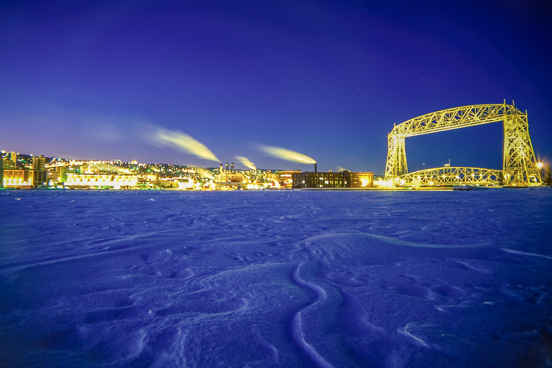 January 11 - Winter NightscapeDeep winter in the Northland reveals many breathtaking scenes; the colder it gets, the more beauty seems to pop out. On a freezing evening in mid-January, the colors saturate blue, and the windblown snow-sculpted drifts become visible.The cold, clear air slaps you in the face and grabs your attention for a brief moment, offering a fleeting piece of art.It is hard to believe that daylight will be noticeably longer in just a few weeks, and while thoughts of springtime are only in retailers' minds as they prepare for the next season, time doesn't wait, and the ability to enjoy today for what it is is a gift from God."For as the rain and the snow come down from heaven and do not return there but water the earth, making it bring forth and sprout, giving seed to the sower and bread to the eater." Isaiah 55:10There are no guarantees for tomorrow; count your blessings and make today matter.
