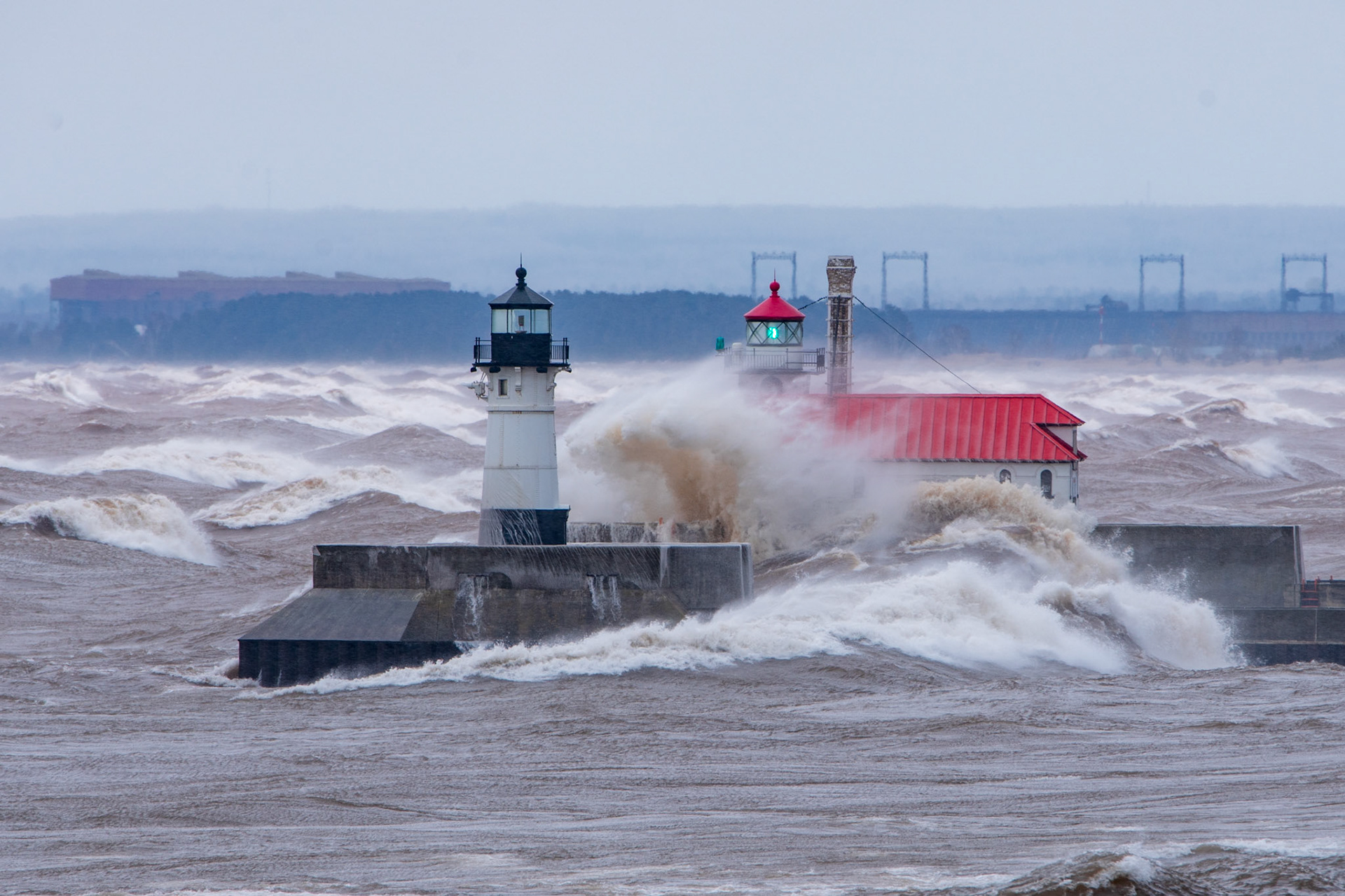 April 16 - April NoreasterDuluth Lighthouses stand up to gale-force winds.  Keeping a tripod steady is challenging in these winds, as is trying to keep spray off the camera lens.These two lighthouses have withstood the beatings of Lake Superior waves for more than a century and are a tribute to the engineering of the early 1900s.He made the storm be still, and the waves of the sea were hushed. Psalm 107:29What storms in your life seem to be overcoming you? With God's help, you can stand like a lighthouse and hold fast to Him.