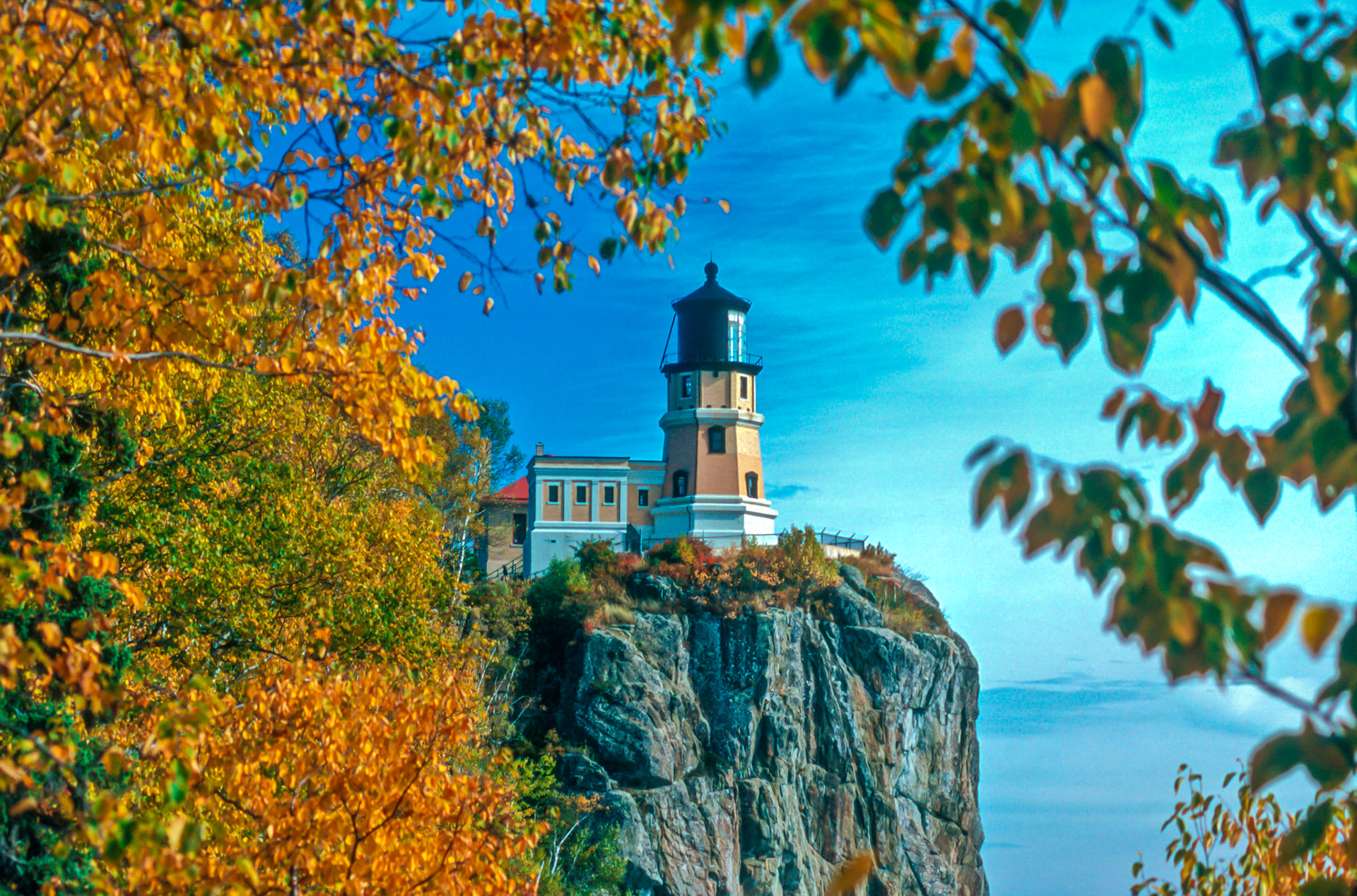 October 3 - Autumn Afternoon at Split Rock Lighthouse - Autumn on the North Shore of Lake Superior is a prime time of year. For a few days in October, your senses are filled with incredible colors, the smell of autumn in the air, and the sound of birds and waterfalls. The season's first frost occurred in late September, which signaled the start of color change. The North Shore is now ablaze with the reds and yellows of autumn. Split Rock Lighthouse sits in the middle of this beauty and provides a perfect centerpiece for this view.Split Rock sits on a firm foundation, much like our faith in Christ, and His light guides our path.The Light of God!Your word is a lamp to my feet and a light to my path. Psalm 119:105