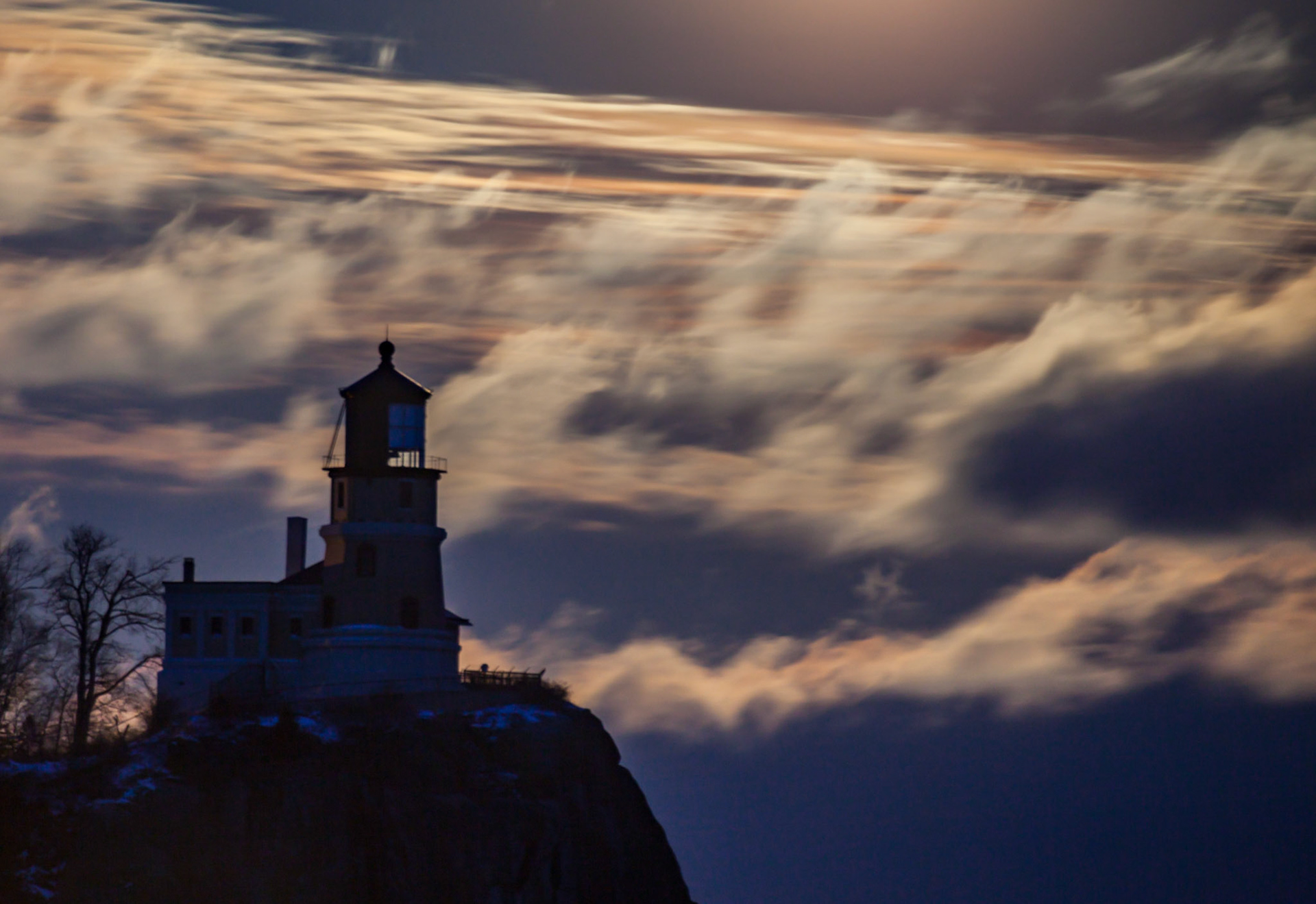November 28 - Lighthouse in the CloudsThe scene is ethereal on a late November night, with a full moon lighting up the clouds above Split Rock Lighthouse.Every good gift and every perfect gift is from above, coming down from the Father of Lights, with whom there is no variation or shadow due to change. James 1:17