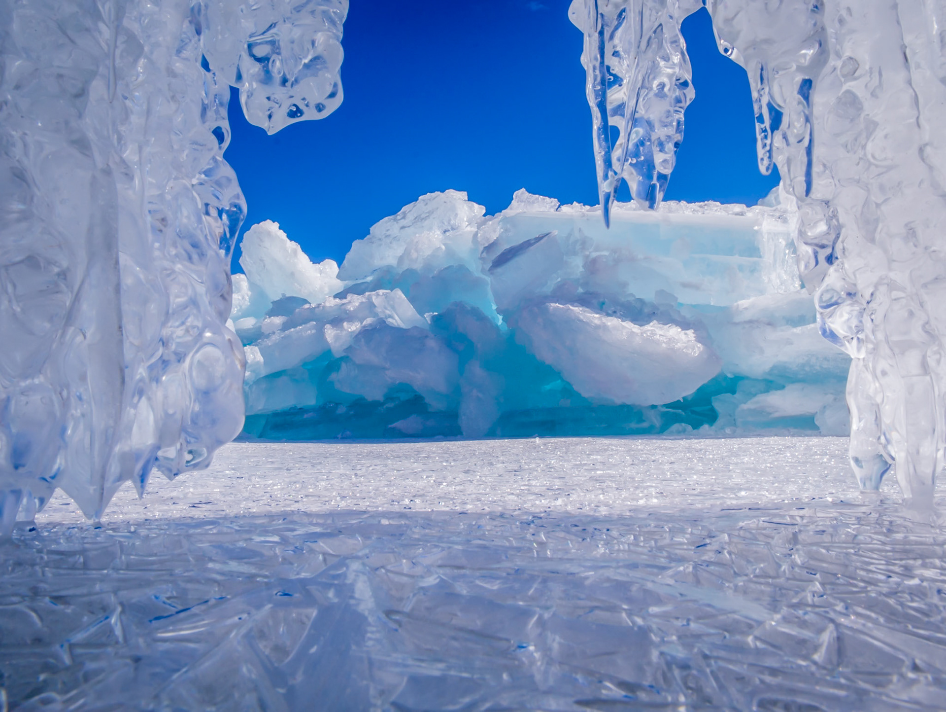 February 20 - Crystal CathedralThick shore ice along Lake Superior creates a beautiful ice cathedral. Late February winds and waves pushed broken ice sheets ashore, forming stunning, clear ice structures.For this scene, I tucked my camera inside one of the cracks in the ice and snapped a quick picture, hoping to capture a view from within the small cavern.Even though the ice field surrounded me, warm sunshine on a late February afternoon was refreshing — a gentle reminder that spring was just around the corner."Have you entered the storehouses of the snow, or have you seen the storehouses of the hail…" — Job 38:22God shapes new ice sculptures by His hand overnight, creating something fresh each day. We receive the same opportunity to renew each day.