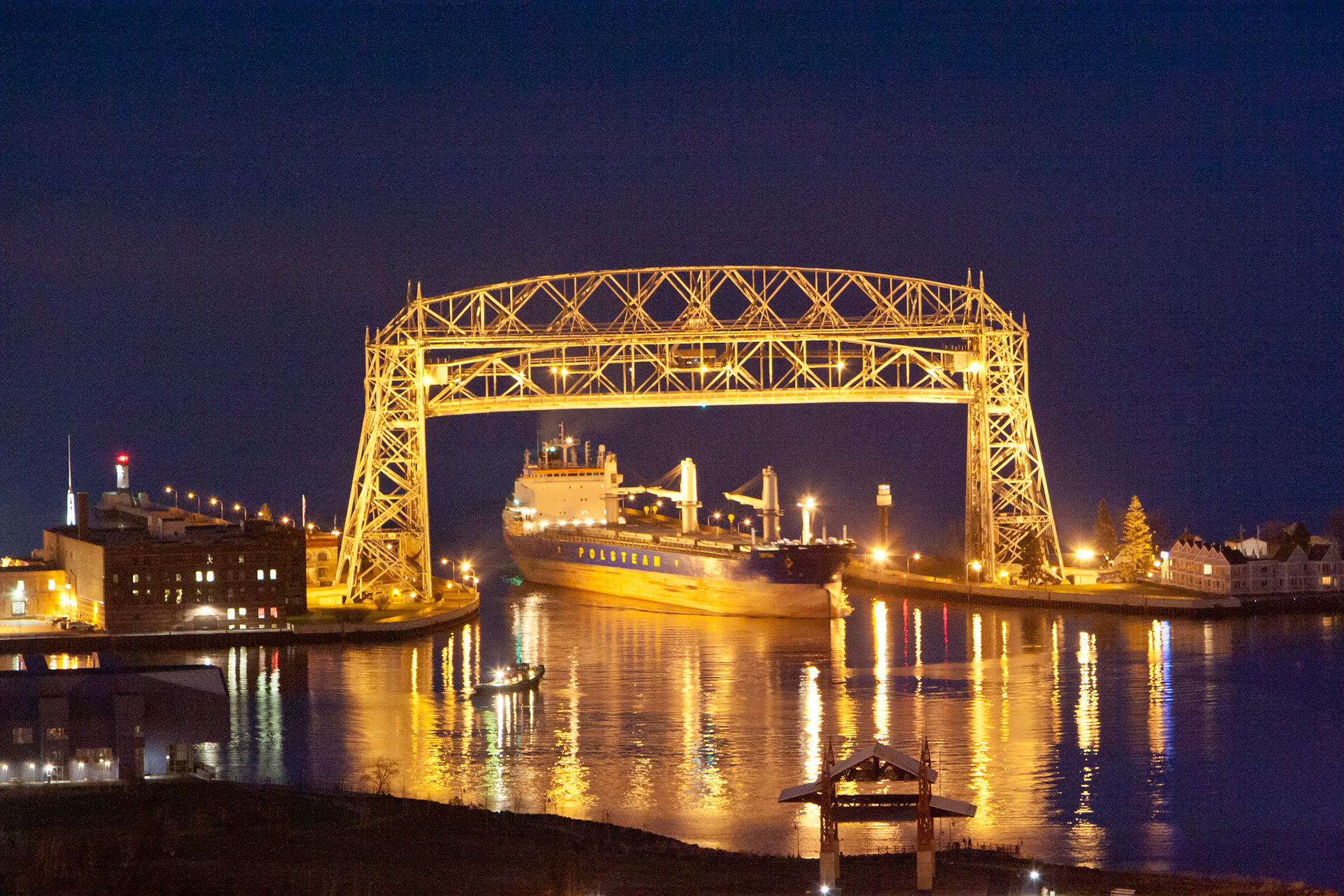 April 9 - Saltie Arrival Arriving under the Aerial Lift Bridge, the Saltie arrived to load grain. Tug boats guide the large vessel through the harbor.Foreign boats need to become more familiar with the harbor and need assistance getting to their dock safely.Proverbs 3:5-6 says, "Trust in the Lord with all your heart and lean not on your understanding; in all your ways submit to him, and he will make your paths straight." This verse reminds us that we should trust God to guide us through life's challenges, just as tug boats guide large vessels through unfamiliar harbors.