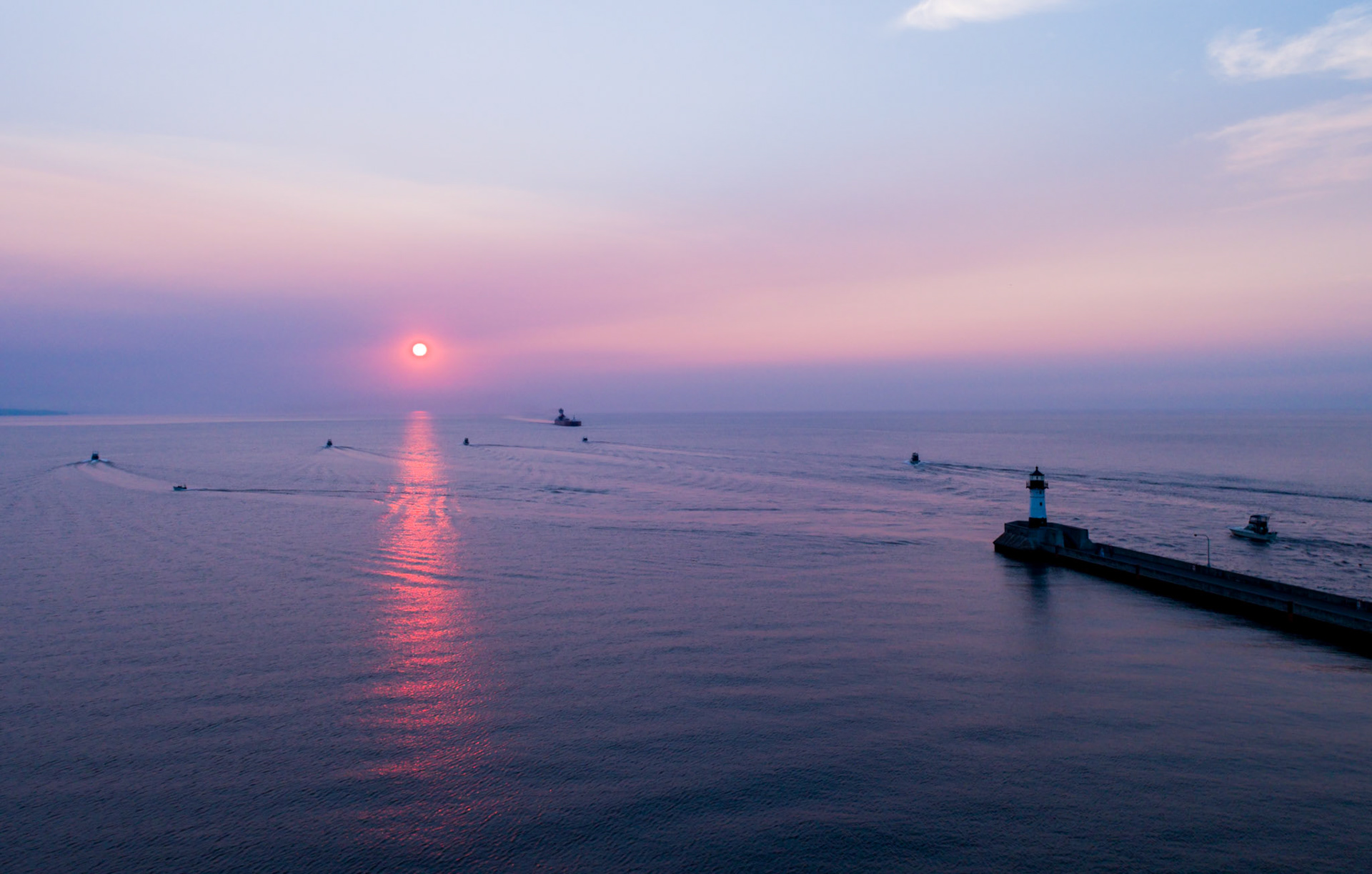 July 20—The Fishing Fleet Departs—Charter fishing boats from Duluth fan out across Lake Superior on a warm mid-July morning. The big lake is abundant with lake trout, salmon, and whitefish, which provide adventure and a meal for many. "The kingdom of heaven is like a net that was let down into the lake and caught all kinds of fish." Matthew 13:47