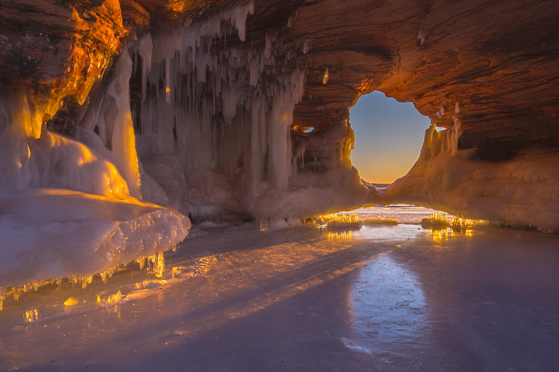 February 27 - Apostle Island Sea CavesThe interior of the Apostle Islands Sea Caves glows with a breathtaking beauty unlike anywhere else on Lake Superior. In late February and early March, when the lake freezes enough to permit safe passage, adventurous explorers can reach these natural wonders by walking across the ice.Over centuries, wave action, freezing, and thawing have carved the sandstone cliffs of the Apostle Islands National Lakeshore. The constant interaction of water, wind, and ice continues to shape the shoreline, creating some of the most remarkable scenery in the Great Lakes.In summer, when explored by kayak, the caves roar with echoes bouncing through hidden chambers. In winter, they fall into a profound silence — a reminder that the ice will soon melt, the light will shift, and the shoreline will continue its endless transformation as the next season arrives."Have you entered the storehouses of the snow, or have you seen the storehouses of the hail…" — Job 38:22Few places on Earth reveal the remarkable wonders of God's creation so completely in one setting — and this is one of them.
