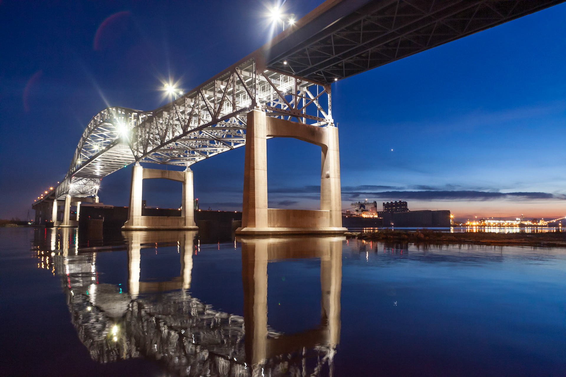 November 19 - Twilight ReflectionEvening calm settles upon the harbor with the reflection of the Blatnik Bridge.As in water, face reflects face, so the heart of man reflects the man. Proverbs 27:19