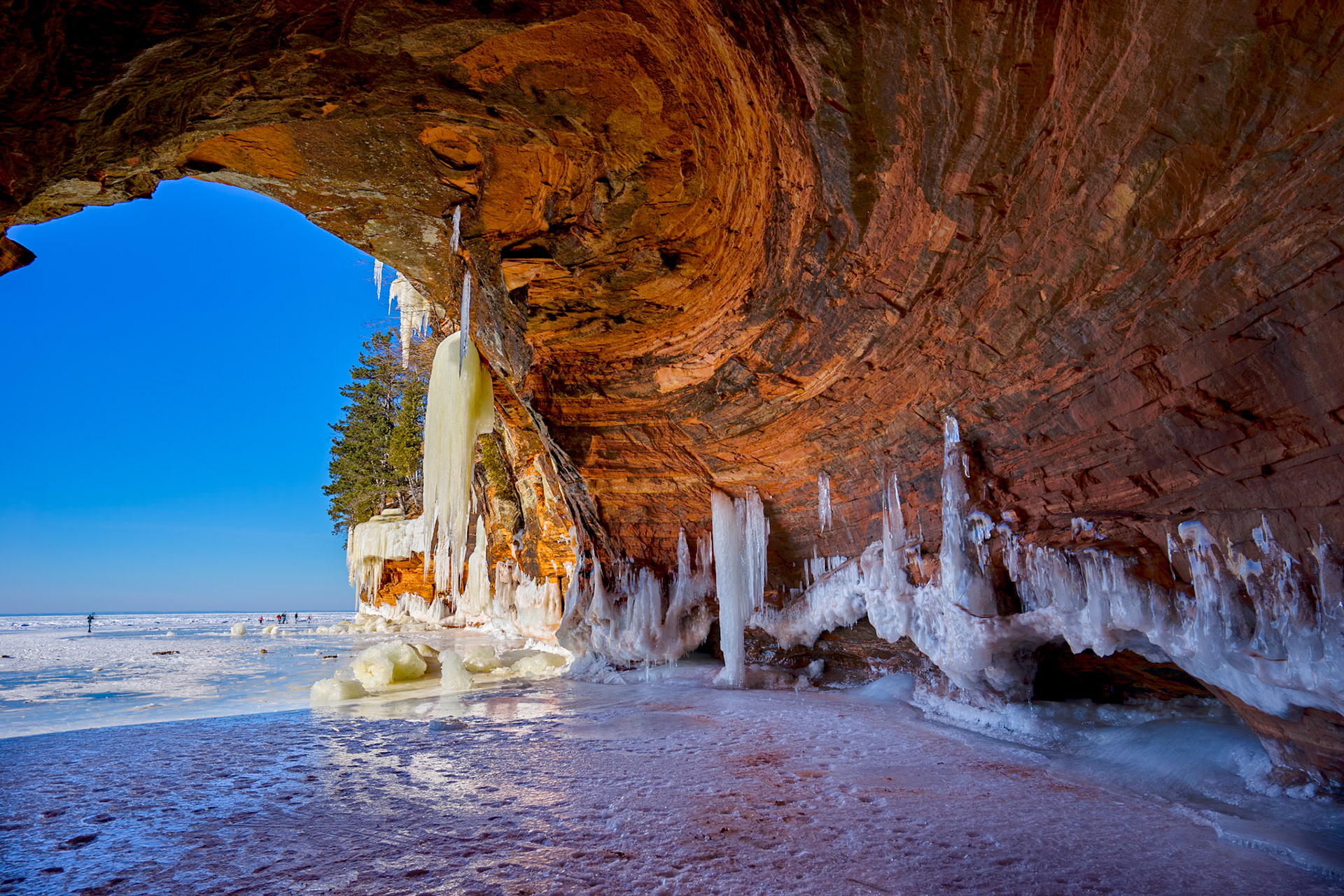 March 16 - Icy CavesThe Apostle Islands sit just offshore from the Bayfield Peninsula on Lake Superior. Over centuries, wind and water have carved the sandstone into sea caves — explored by boat in summer and by foot across frozen water in winter.When winter settles in, the caves transform. Ice clings to the ceilings and drapes down the walls. The multicolored sandstone glows against the blue sky and frozen lake, and every sound seems to echo with wonder.These caves are one of the region’s treasures — a place where heaven and earth feel close. As visitors step inside, their whispered conversations often rise into a shared “Wow,” carried and multiplied by the stone.“Be exalted, O God, above the heavens! Let your glory be over all the earth!” — Psalm 57:5Creation speaks in seasons. Water shapes rock. Ice forms and melts. Echoes rise and fade. Yet through every cycle, the glory of God remains. Everything in creation points to the God of the Bible, and the Bible points to the God of creation.