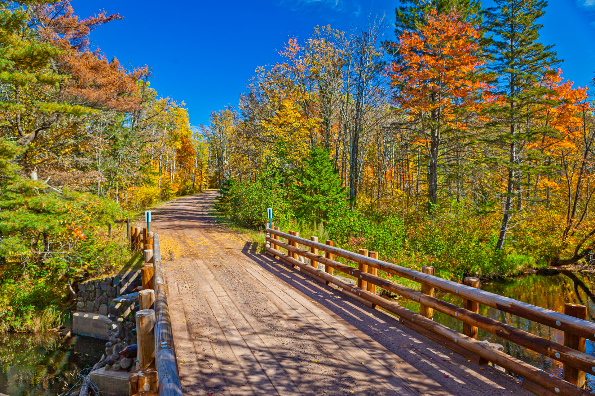 September 30 - Crossing into October  With Autumn colors in full display now, September is ending in all its wonderful tapestry of color. The falling leaves blanket the earth in a colorful mosaic of warm color.The wooden bridge in this image crosses the St. Croix River at St. Croix State Park as the road heads into the multi-colored forest.The falling leaves blanket the earth in a colorful mosaic, and as the seasons move on, they will soon be ready to fertilize the new growth next spring. The Peace of ChristDo not be anxious about anything, but in everything by prayer and supplication with thanksgiving, let your requests be made known to God. Philippians 4:6