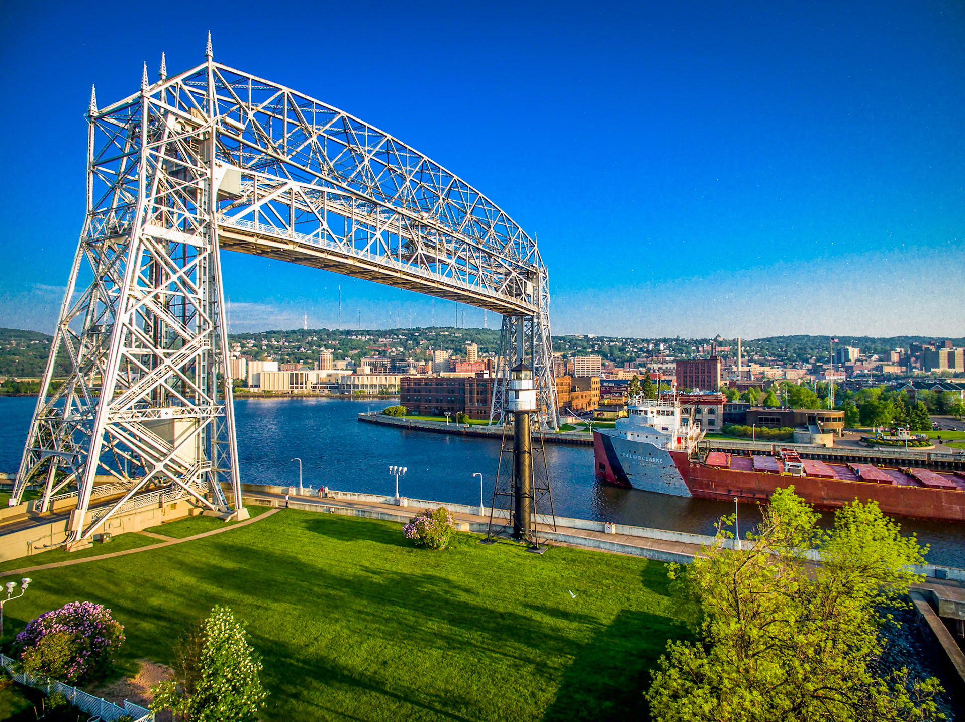 June 10—Philip R Clarke—On a warm summer morning, The Philip R Clarke arrives under the Duluth Aerial Lift Bridge."Even though I walk through the darkest valley, I will fear no evil, for you are with me; your rod and your staff comfort me"—Psalm 23:4. This scripture serves as a constant reminder that no matter how treacherous the journey, we need not fear. For God is not a distant figure but a constant companion, guiding and protecting us every step of the way. We can trust in His unwavering presence to provide us with safe passage, even through the harshest of circumstances.