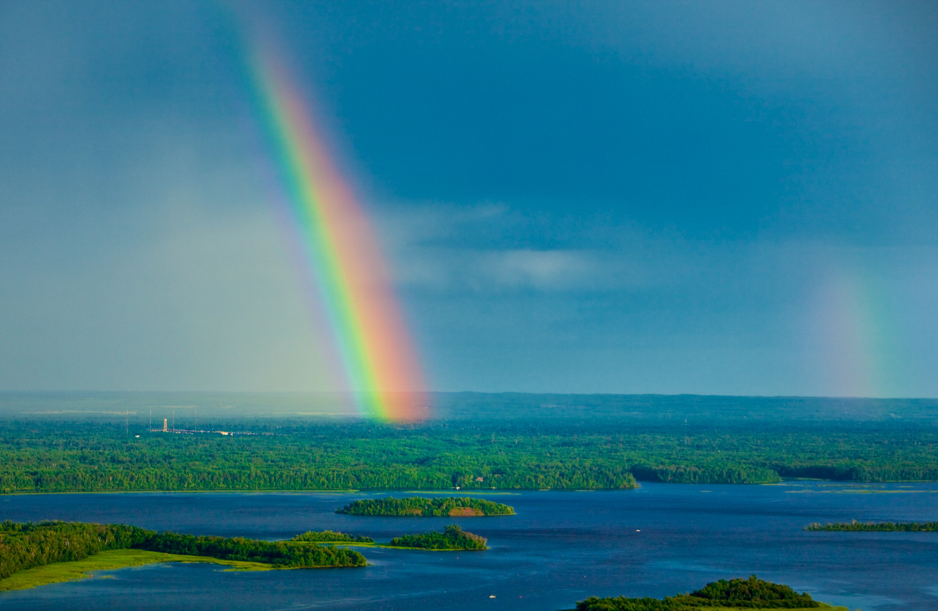 July 22 - Rainbows over St. Louis River - Passing showers during July often produce amazing rainbows across the Northland. This double rainbow marched through the skies following a late afternoon thunderstorm. A double rainbow occurs when the light is reflected twice in a separate shower from two directions. Notice that the second rainbow is slightly higher and fainter in color than the first rainbow and has its colors reversed.The rainbow has always been a sign of hope. So the next time you see a rainbow, remember that God placed it there for you to remember Him.When the rainbow is in the clouds, I will see it and remember the everlasting covenant between God and every living creature of all flesh that is on the earth.” Genesis 9:16